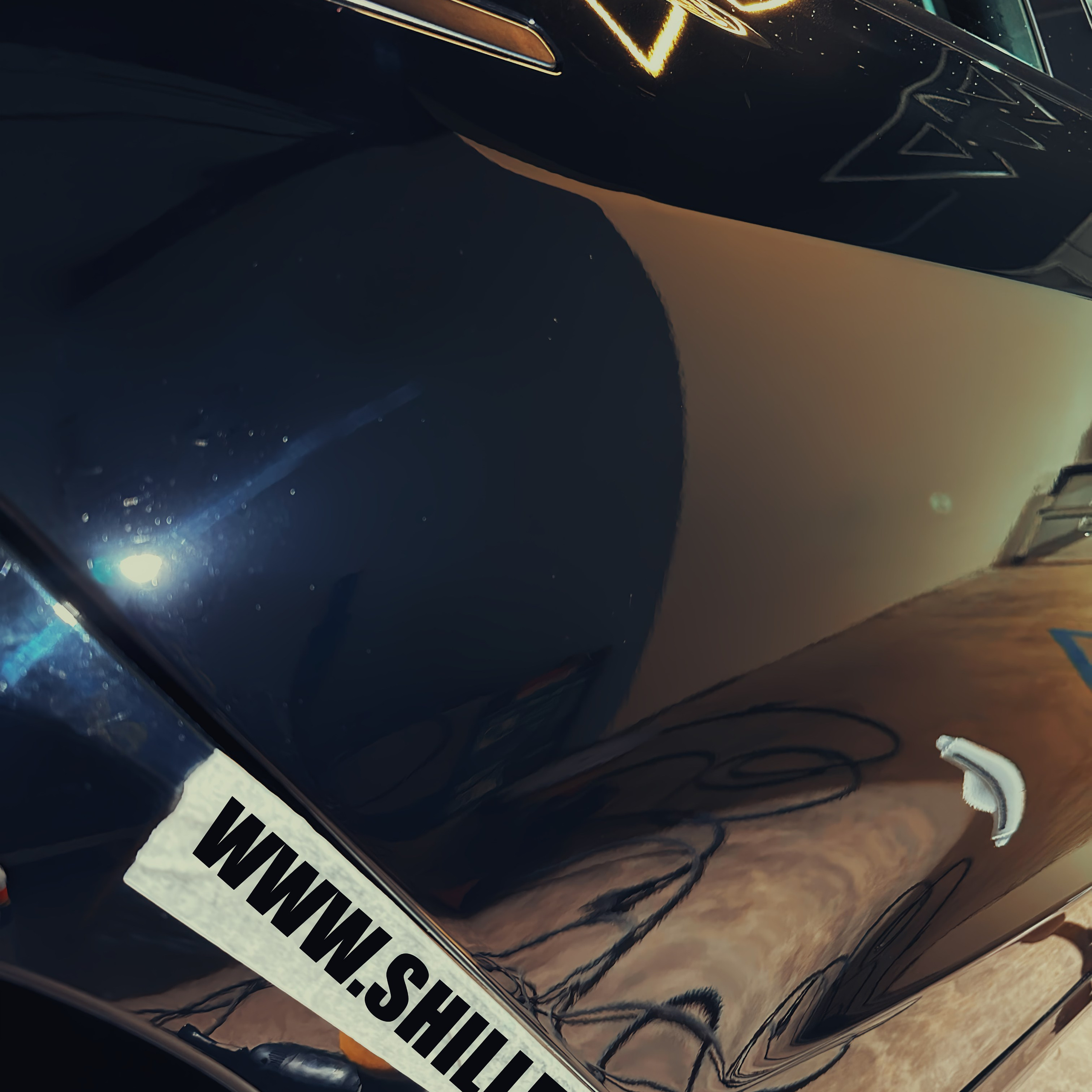 Мастер детейлинга выполняет полировку кузова автомобиля для восстановления блеска