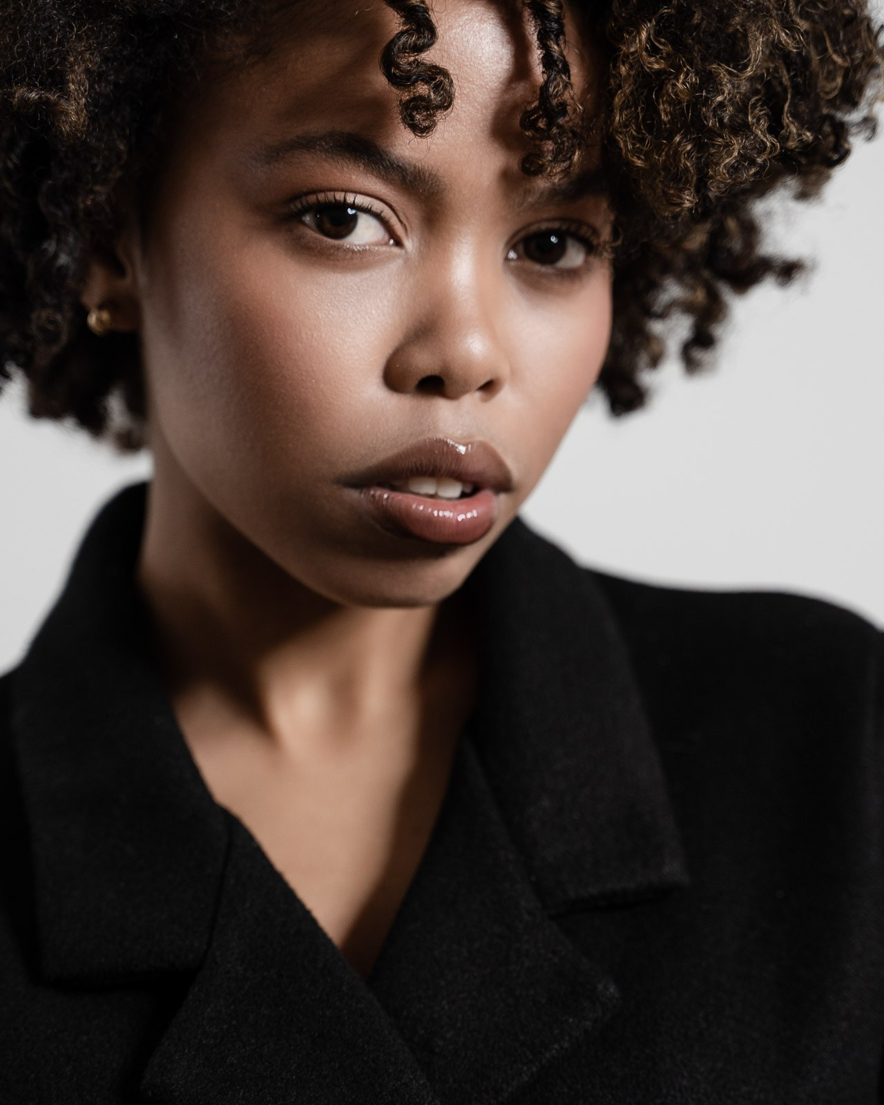 Close-up portrait of female model with curly hair and natural makeup