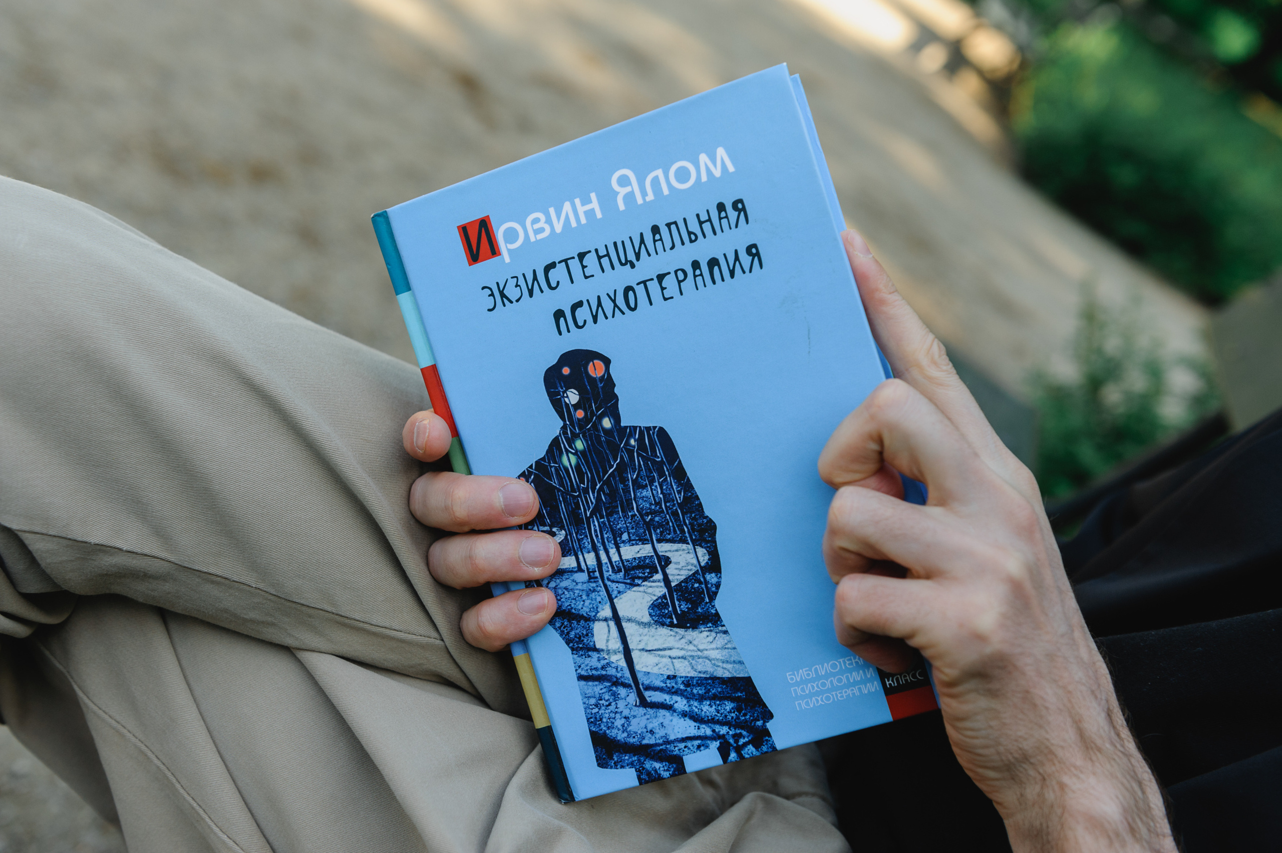 Книга "Эксистенциальная психотерапия" в руках у молодого человека.
