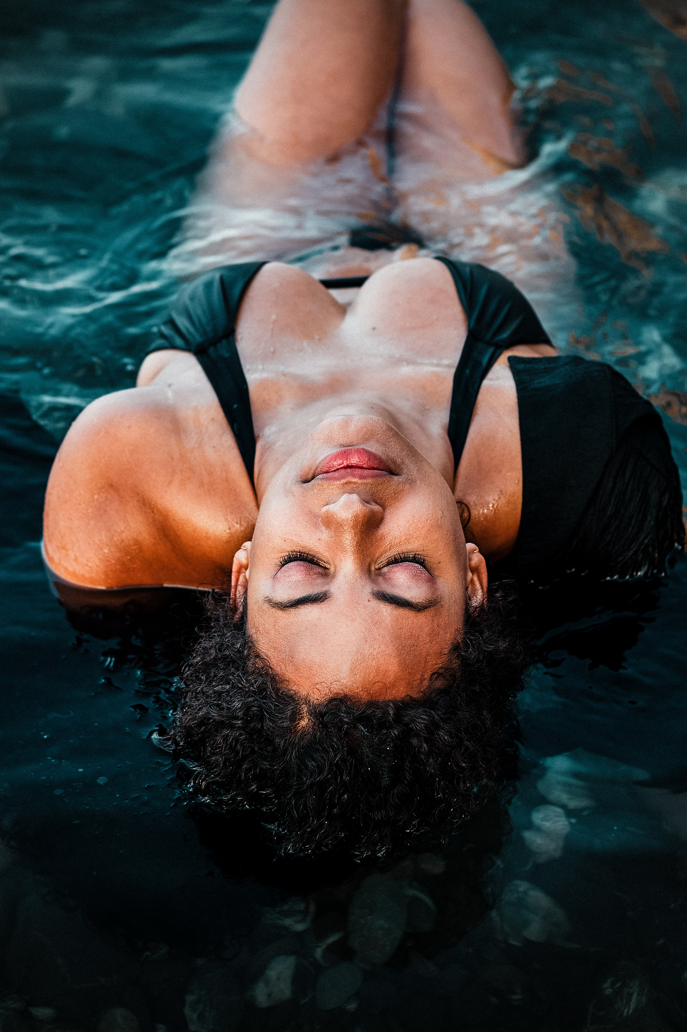 Boudoir photo of a girl with the closed eyes in the clear water of the sea