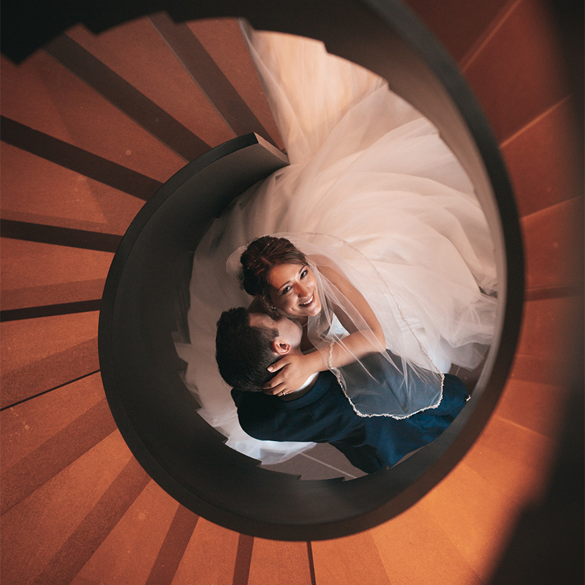 Ein glüchliches Brautpaar, abgelichtet von einem Hochzeitsfotografen. Ein Brautpaar freut sich über Videoaufnahmen von der Hochzeit