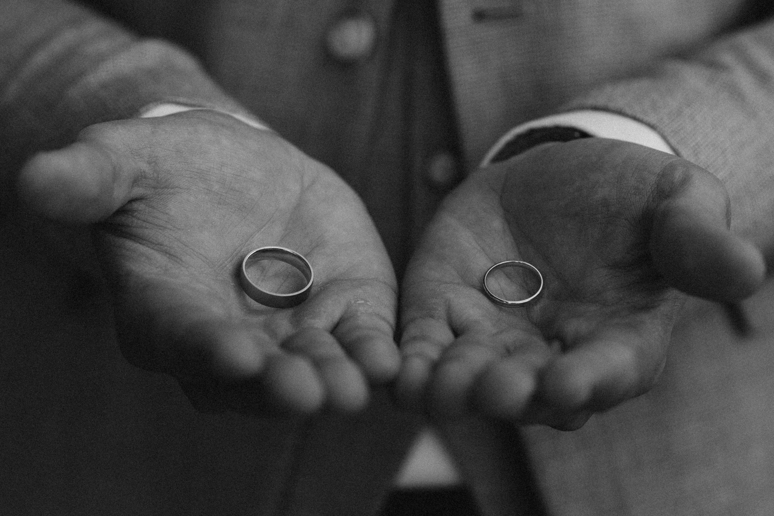 Bräutigam hält die Trauringe.