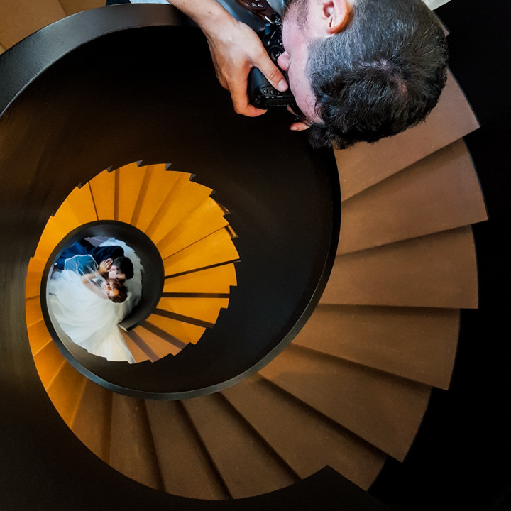 Hochzeitsfotograf macht Foto vom Brautpaar. Ein Hochzeitsvideograf macht dabei auch Videoaufnahmen für diese Hochzeit.