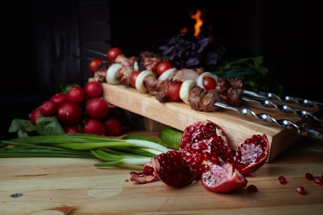 Photographie culinaire de brochettes grillées avec légumes frais sur planche en bois – ambiance rustique et chaleureuse