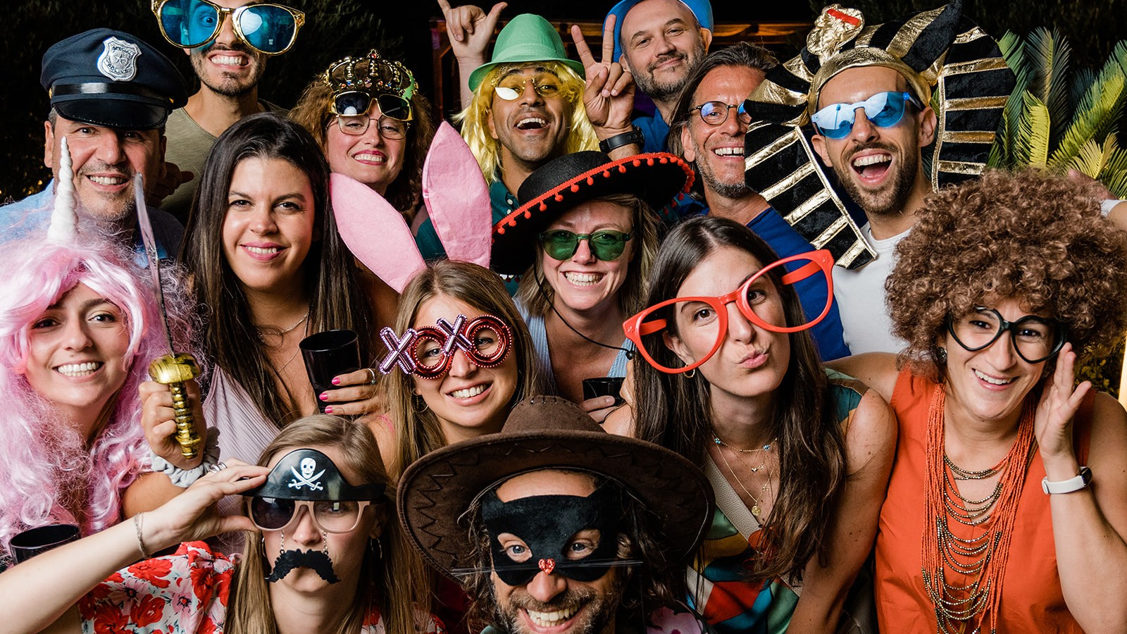 Gruppo di persone che si diverte al servizio photobooth con stampa immediata ad un evento, con gadget e accessori per fare le foto buffe