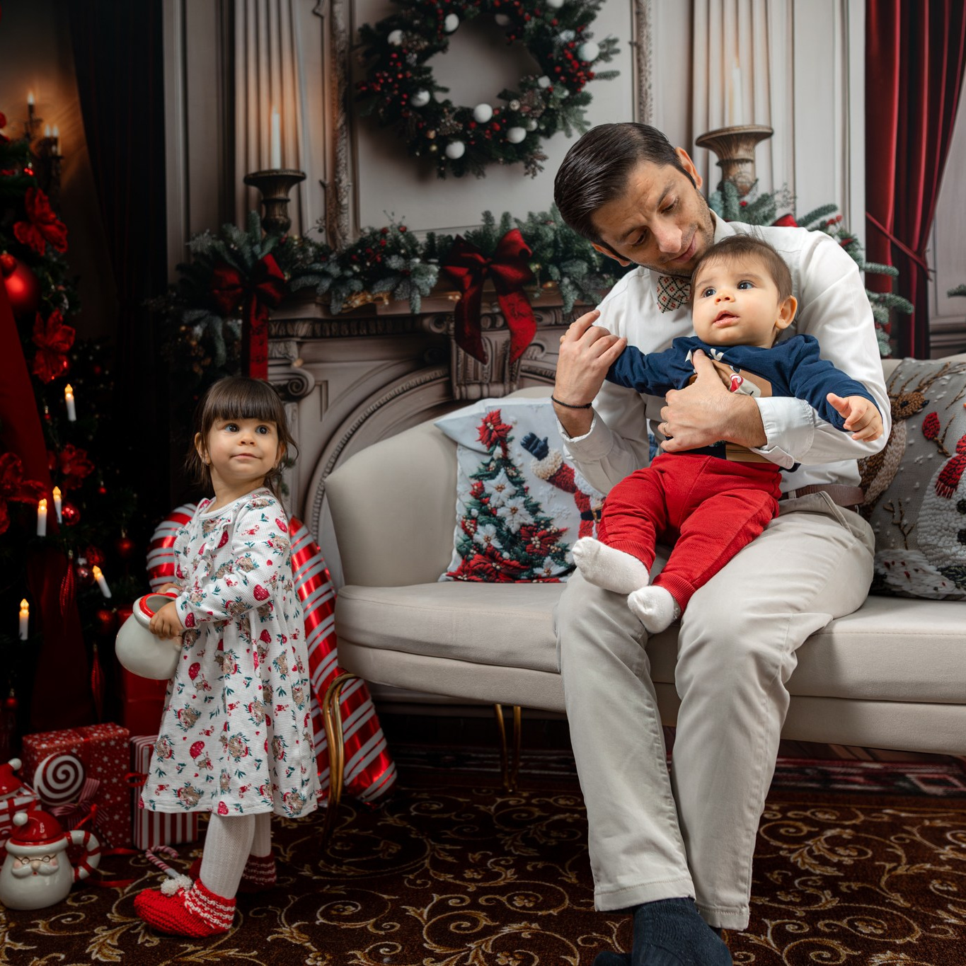 Ședință foto de Crăciun în studio, familie zâmbitoare lângă brad împodobit, decor festiv și lumini calde de sărbătoare