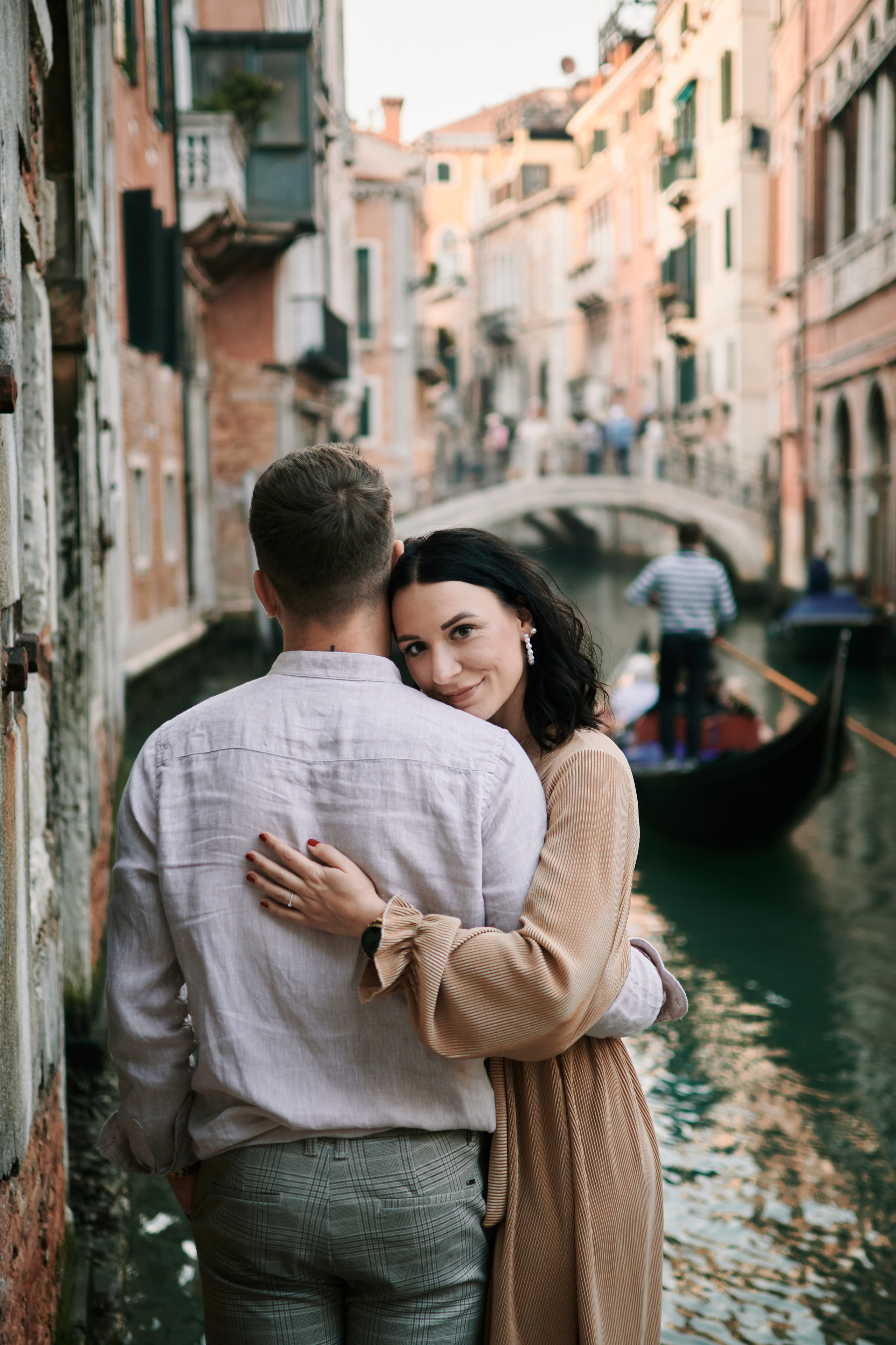 A family poses in front of a Venetian bridge, capturing their memorable vacation in Venice.