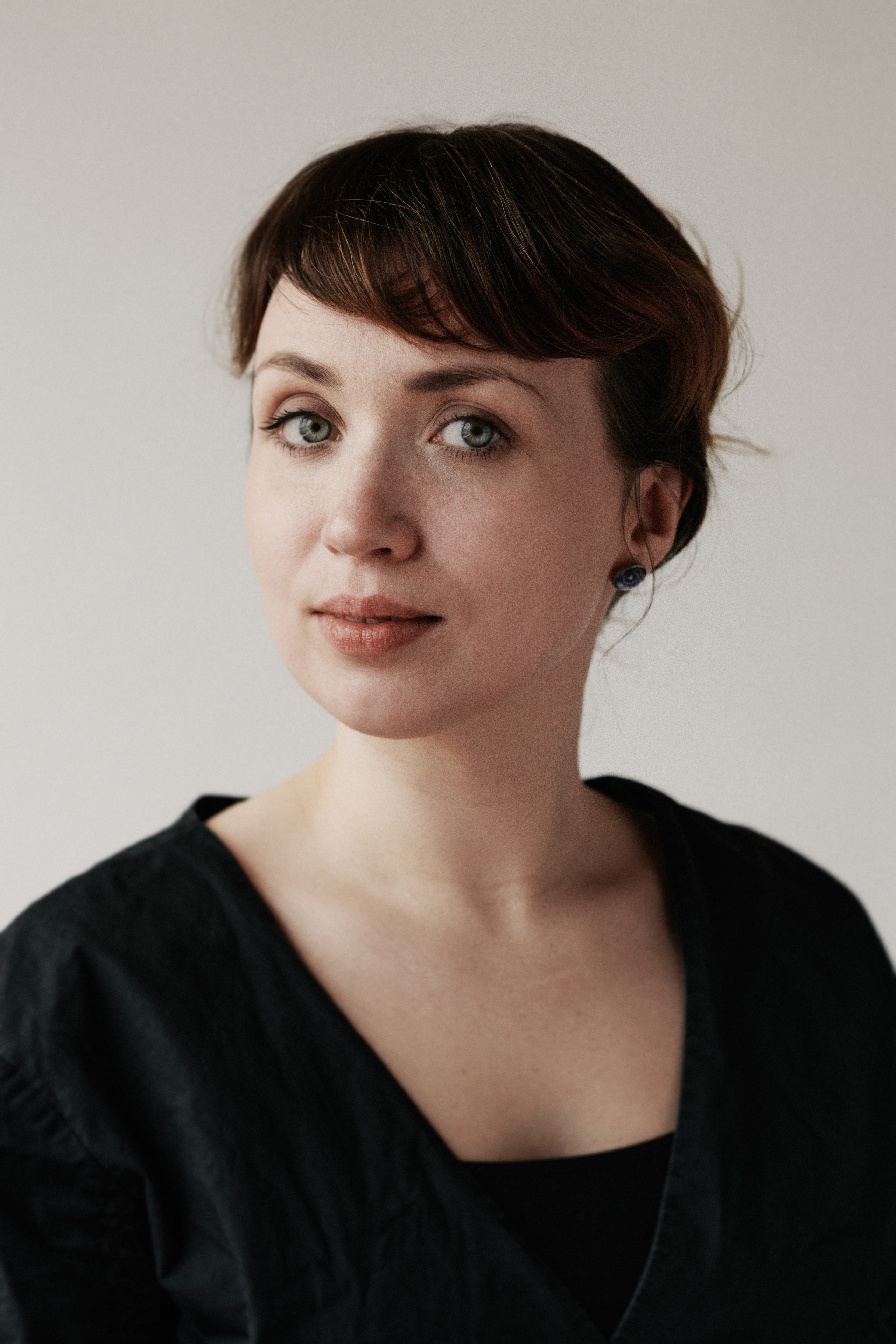 Portretfotografie van een jonge vrouw in een zwarte jurk en rood haar, de fotos zijn genomen in een studio in Almere.