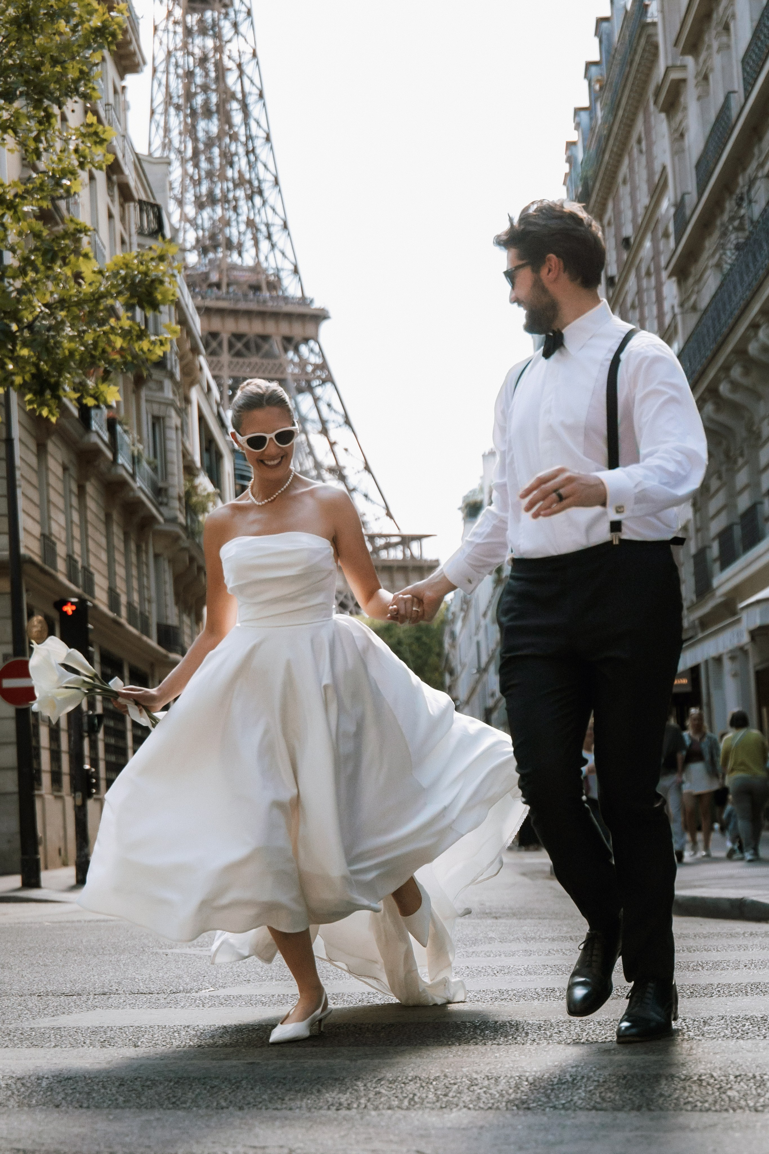 Bride and groom walking through romantic Paris street with soft morning light and elegant editorial styleTimeless Paris elopement photo with bride holding bouquet in golden hourCouple kissing in front of Eiffel Tower – luxury wedding photography in Paris
