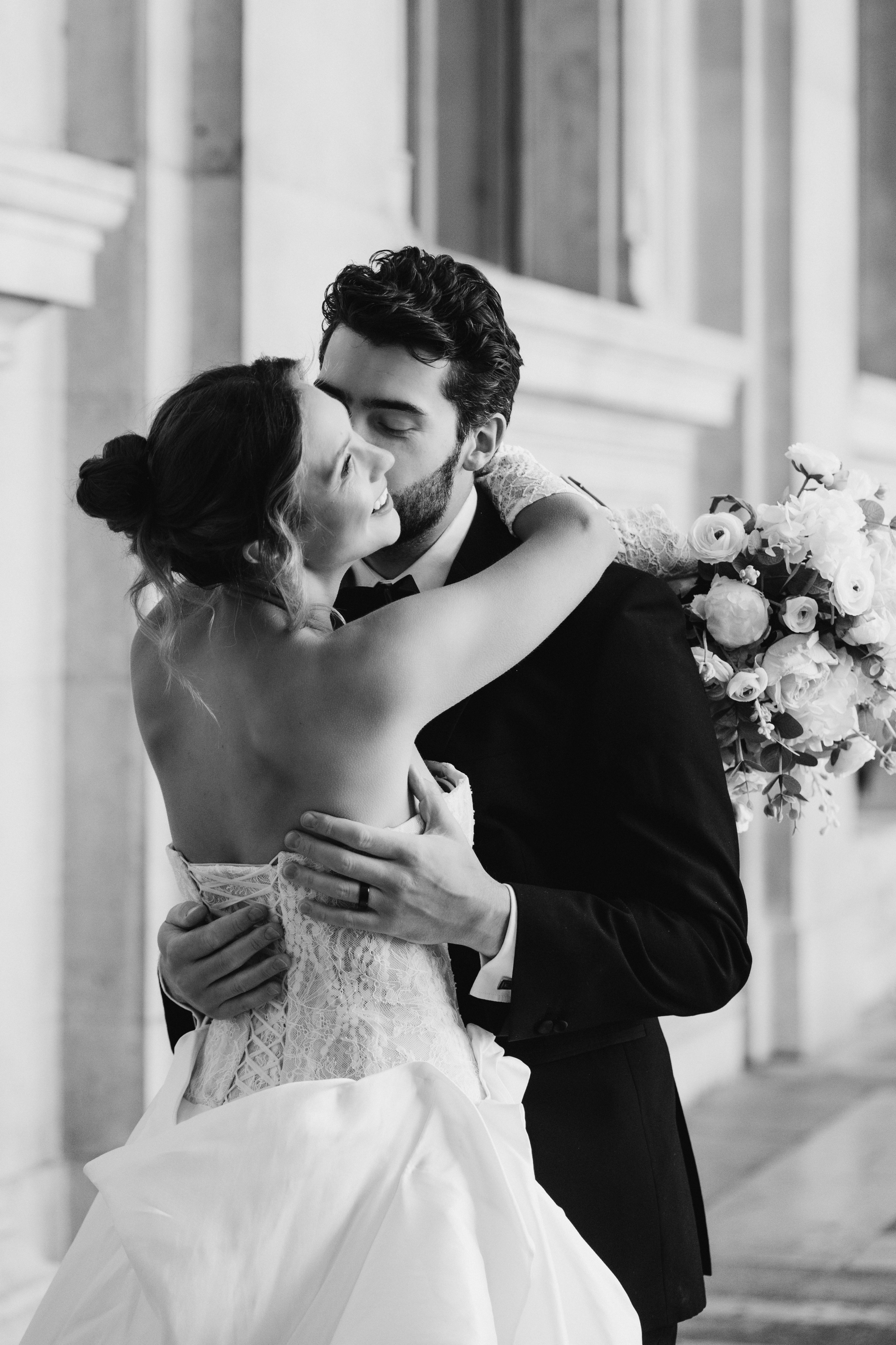 Bride and groom walking through romantic Paris street with soft morning light and elegant editorial styleTimeless Paris elopement photo with bride holding bouquet in golden hourCouple kissing in front of Eiffel Tower – luxury wedding photography in Paris
