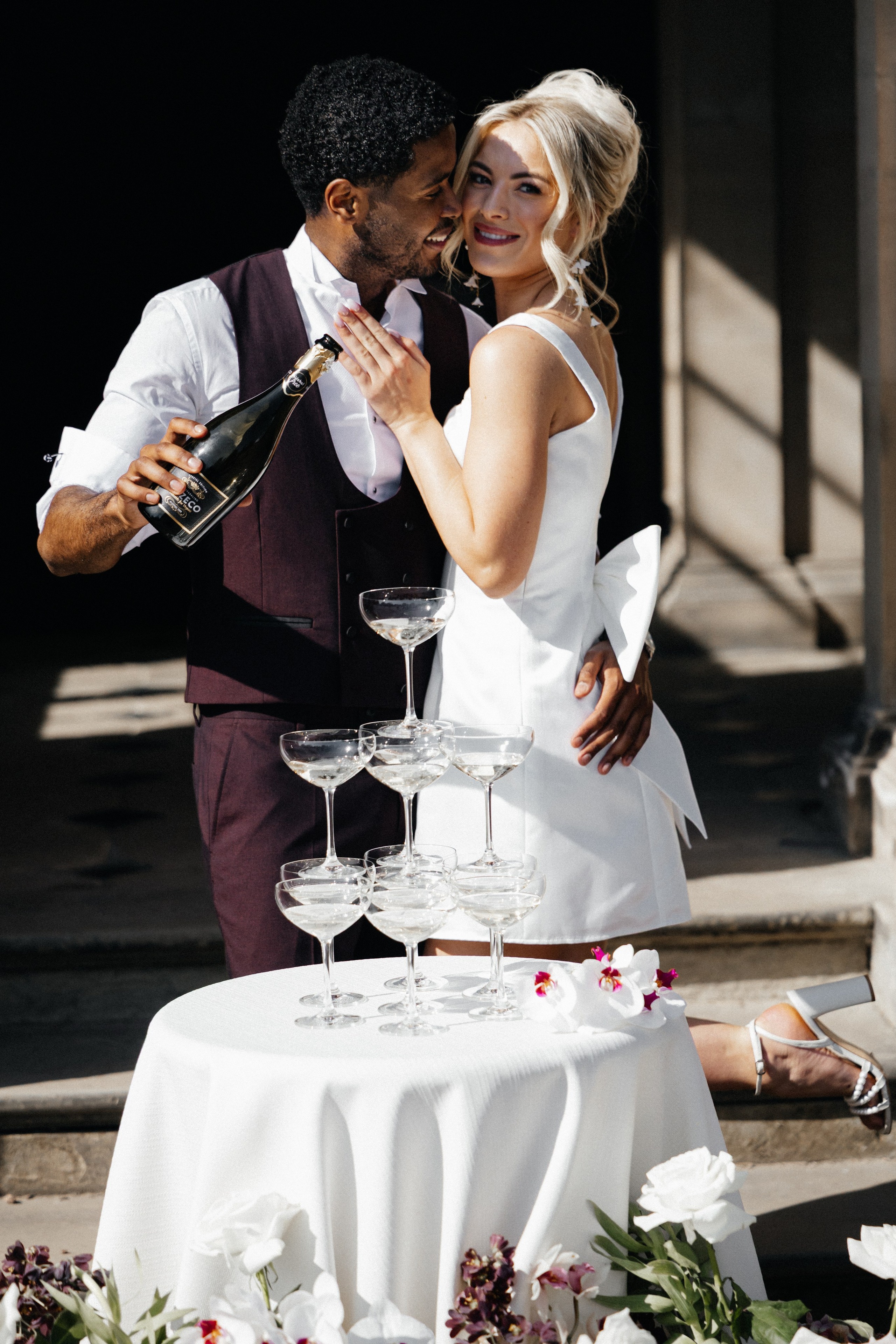 Modern bride and groom in London streets near Marylebone Town HallCandid editorial moment of couple laughing outside Home House wedding venueStylish couple on London steps – timeless black and white wedding portrait