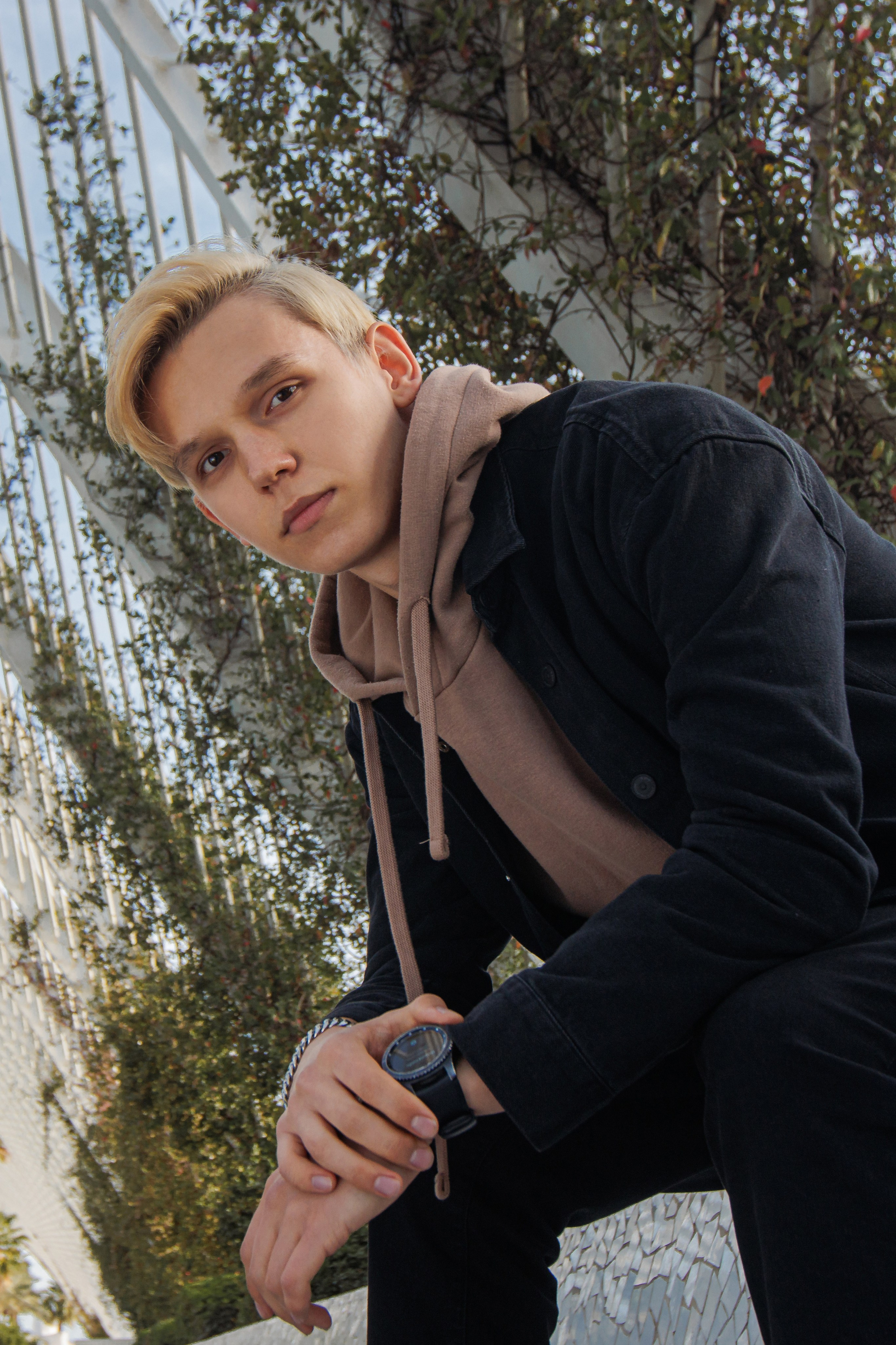 Foto de un chico con chaqueta negra con el telón de fondo de la Ciudad de las Ciencias y las Artes de Valencia