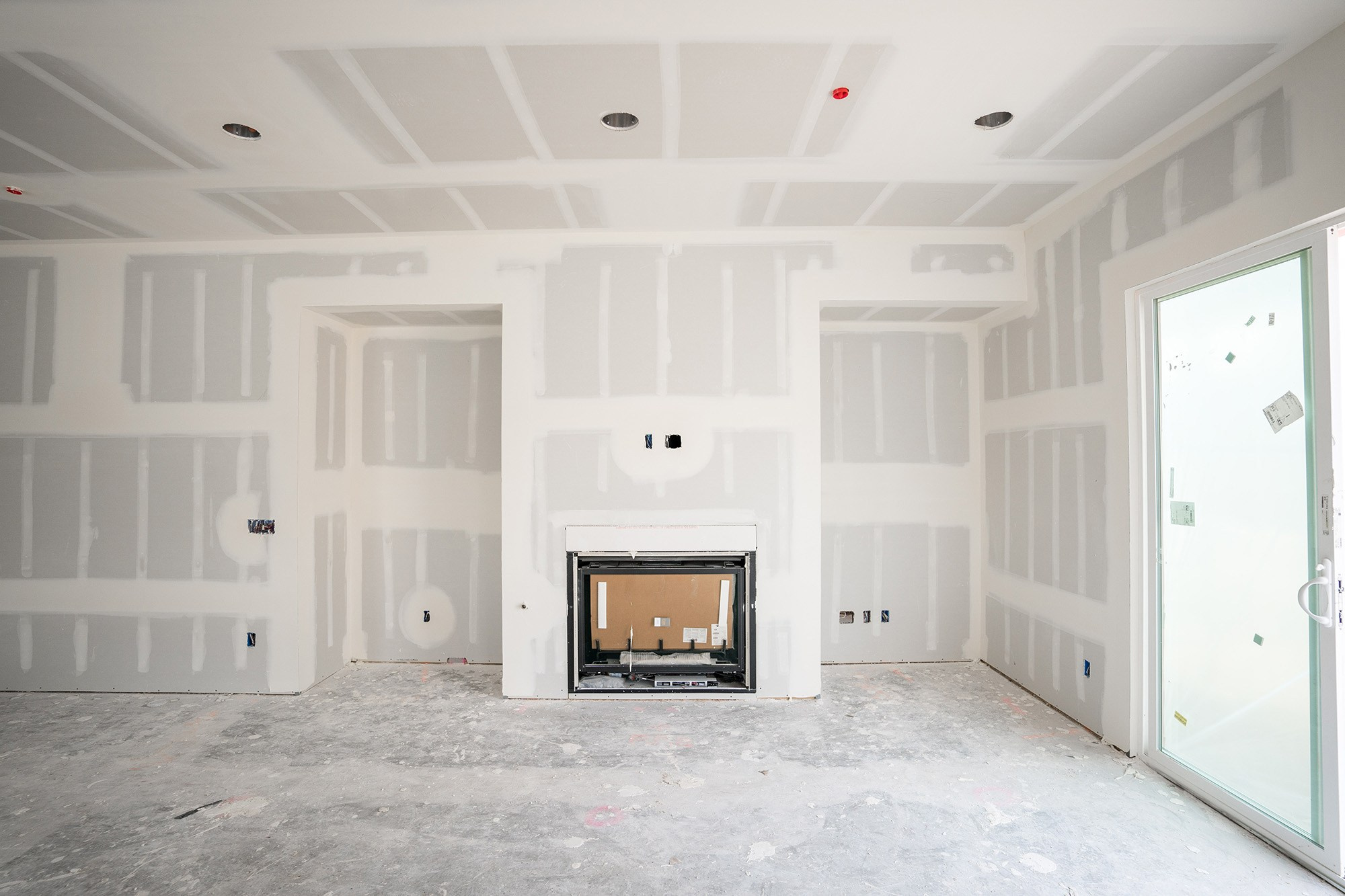 Interior of an Athens apartment under renovation, showing newly installed plasterboard walls, framed doorways, and renovation progress.