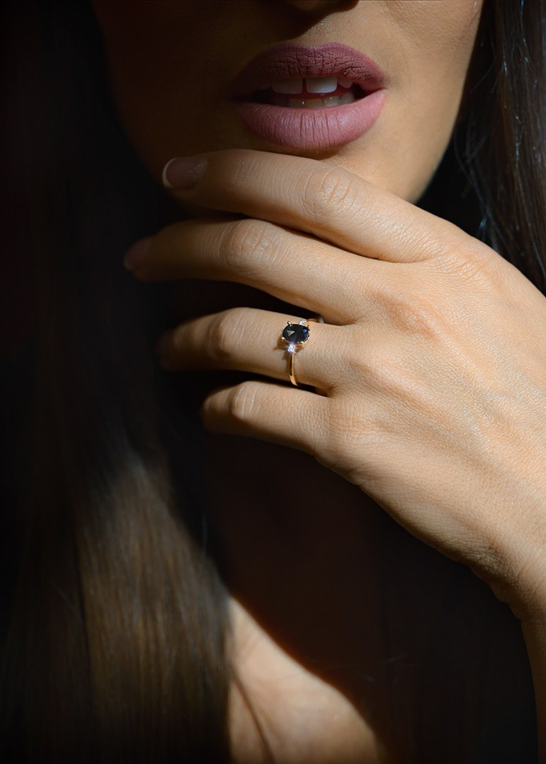 Prsten na ruci devojke sa ljubičastim kamenom