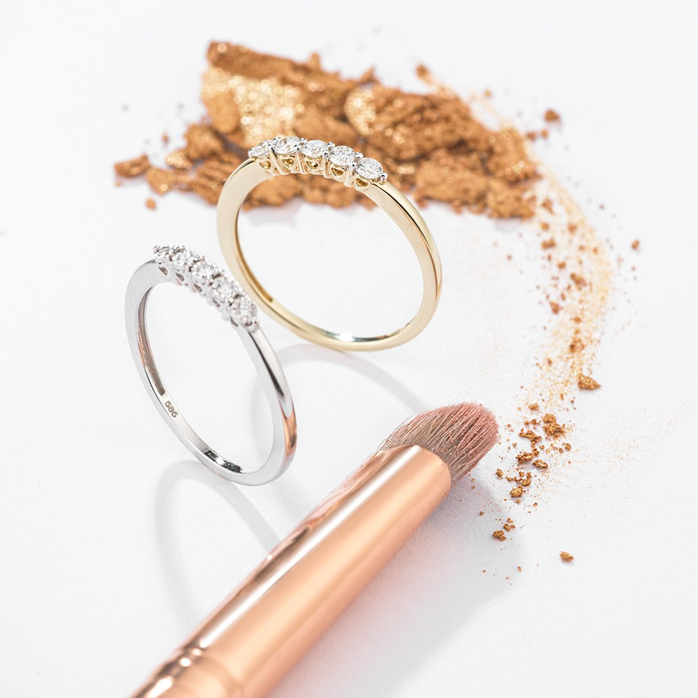 Par zlanog prstenja na bleloj pozadini i šminka.