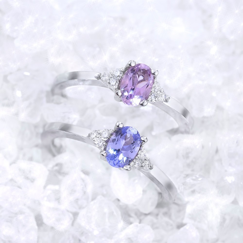 Dva zlatan prtena sa dragim kamenjem u gomili nebrušenih dijamanata.