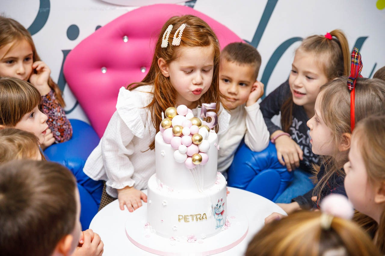 Svečani trenutak sa tortom na dečjoj proslavi.