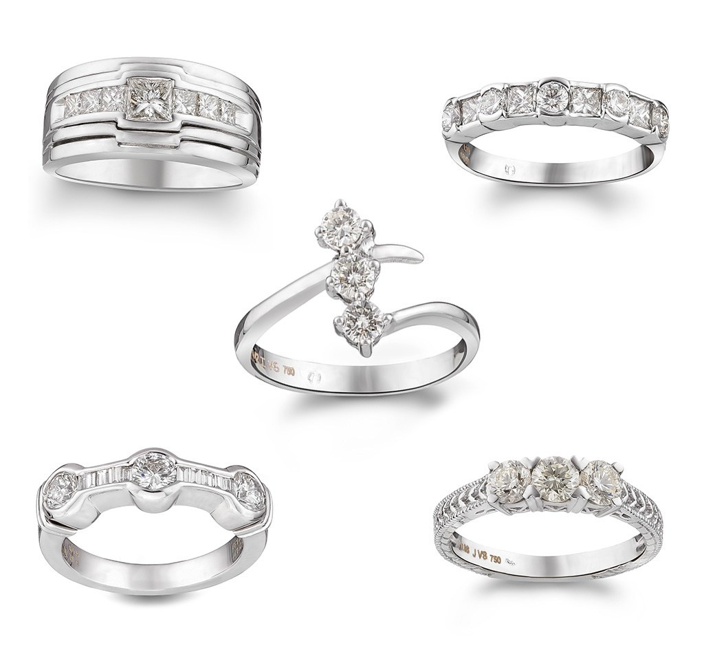 Pet zlatnih dijamantskih prstena na beloj pozadini.