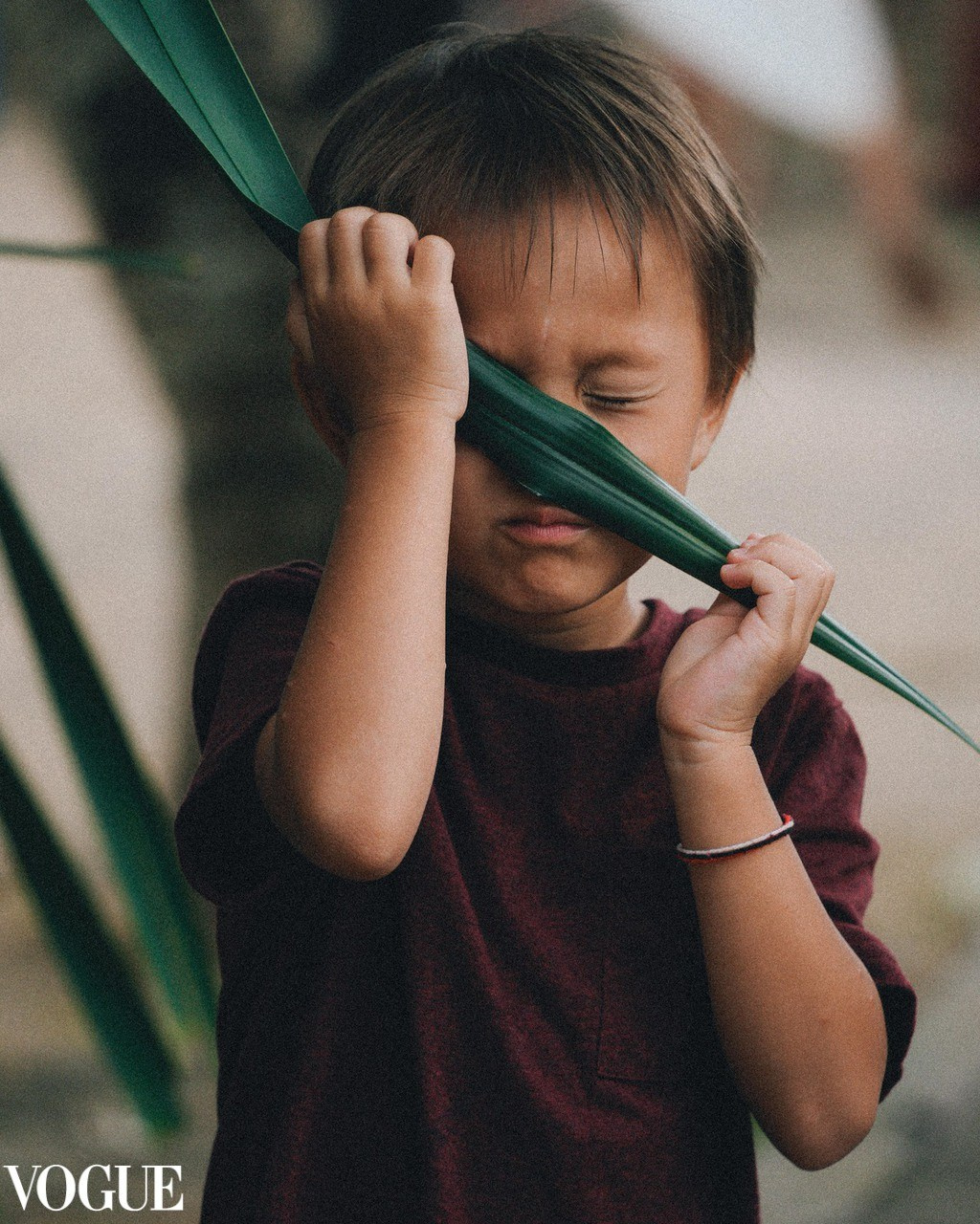 Kids photography in Vogue. Boy hiding behind the leaf. Family photographer Solihull and Birmingham.
