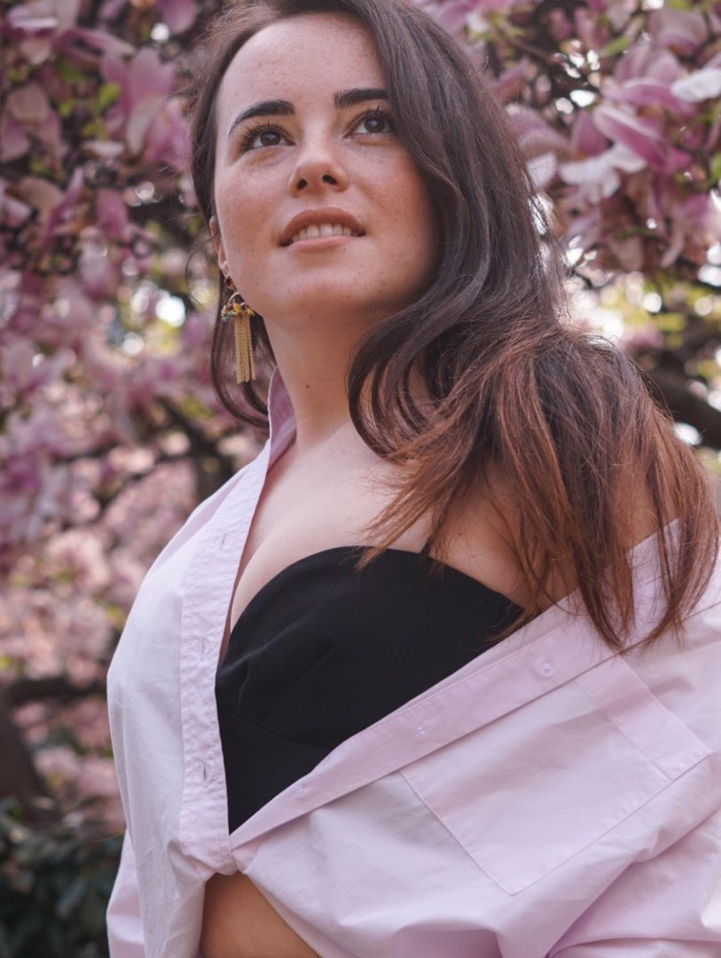 Ragazza davanti a un albero di magnolia in fiore.