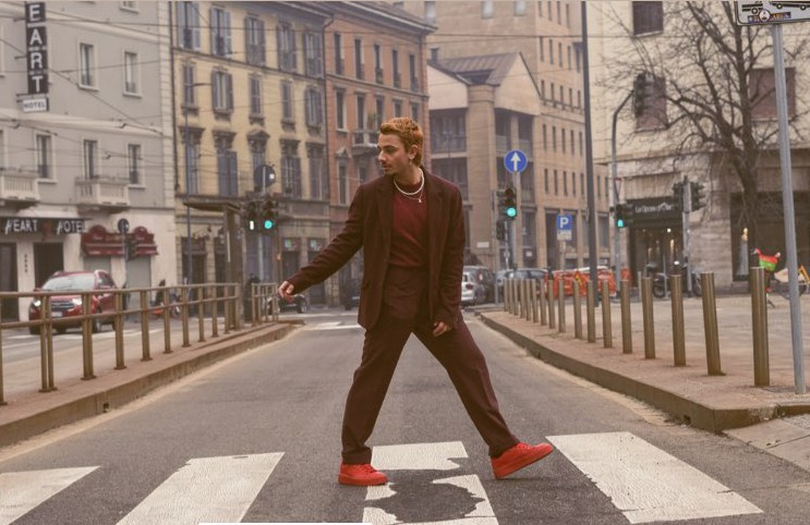 Young man walking through the streets of Milan early in the morning, enjoying the city.