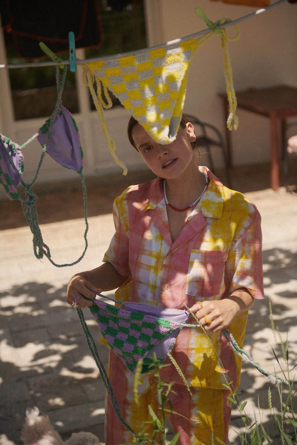 Creative life-style photography of a model in pejama suit for beachwear brand, taken in a countryside garden