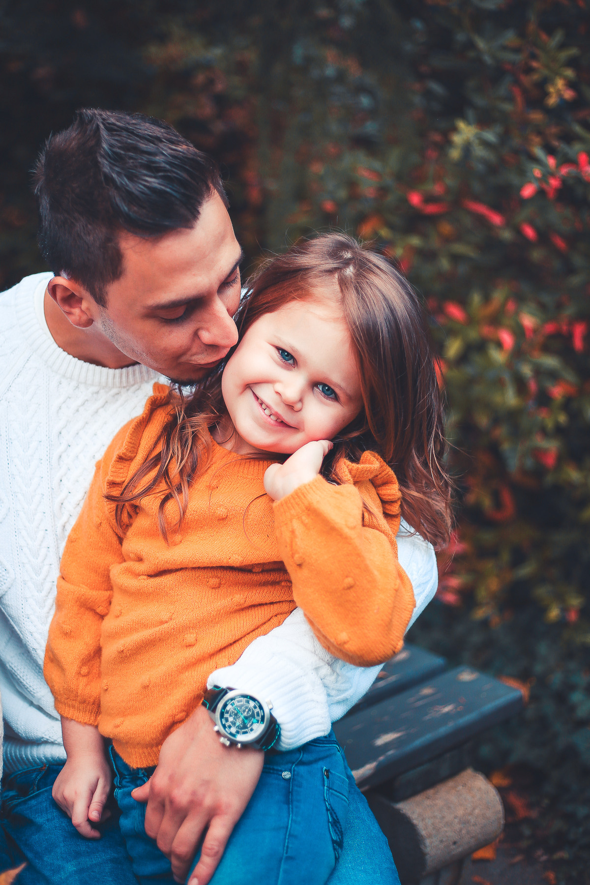 Papa kuschelt mit kleine Tochter im Park Herbst