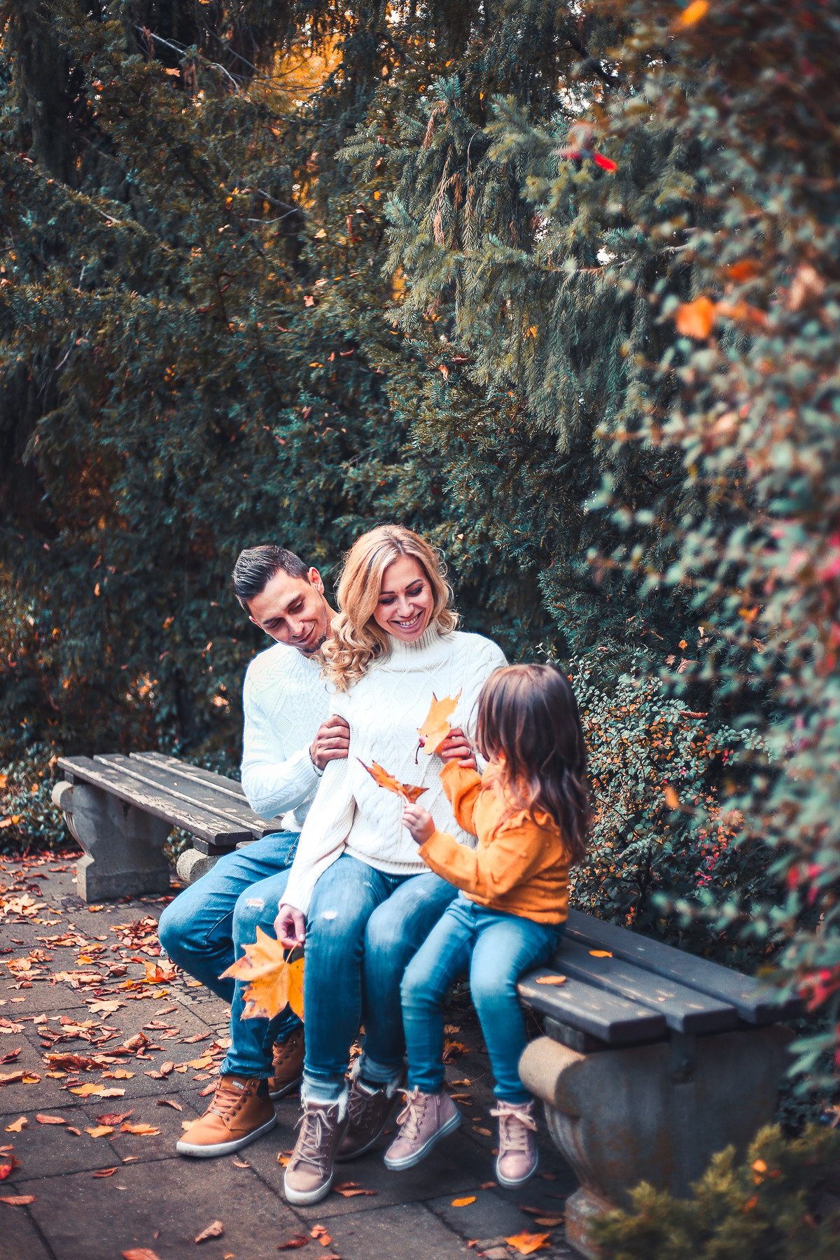 Familie sitzt auf dem Bank im Park Herbst