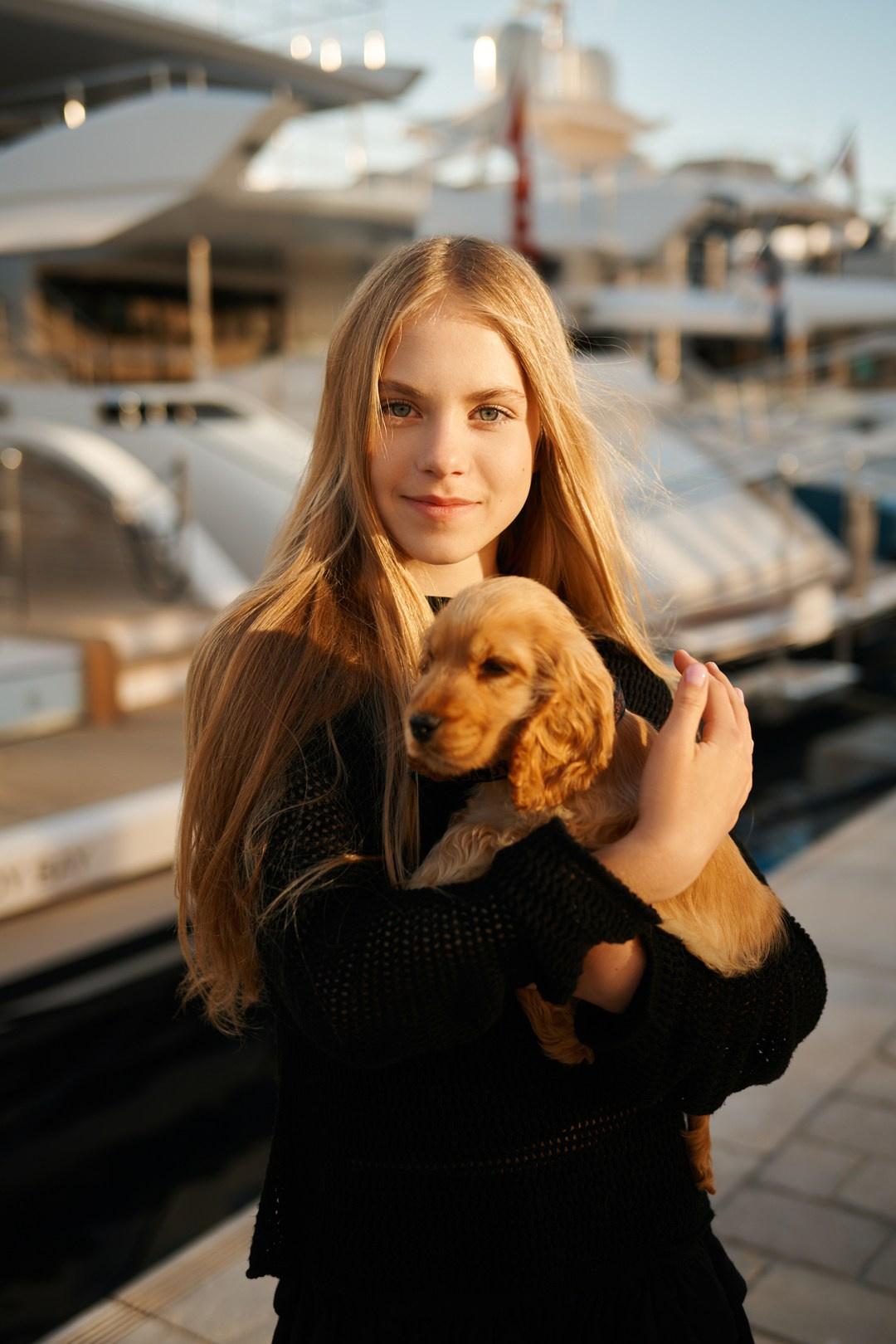 Daughter playing with puppy near luxury yachts at Cannes marina