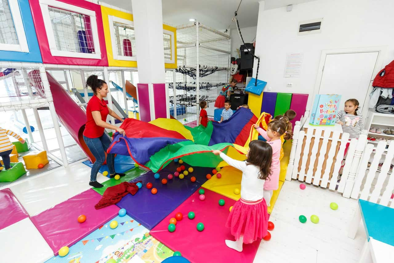 Dečija zabava u igraonici sa šarenim podom i aktivnostima.