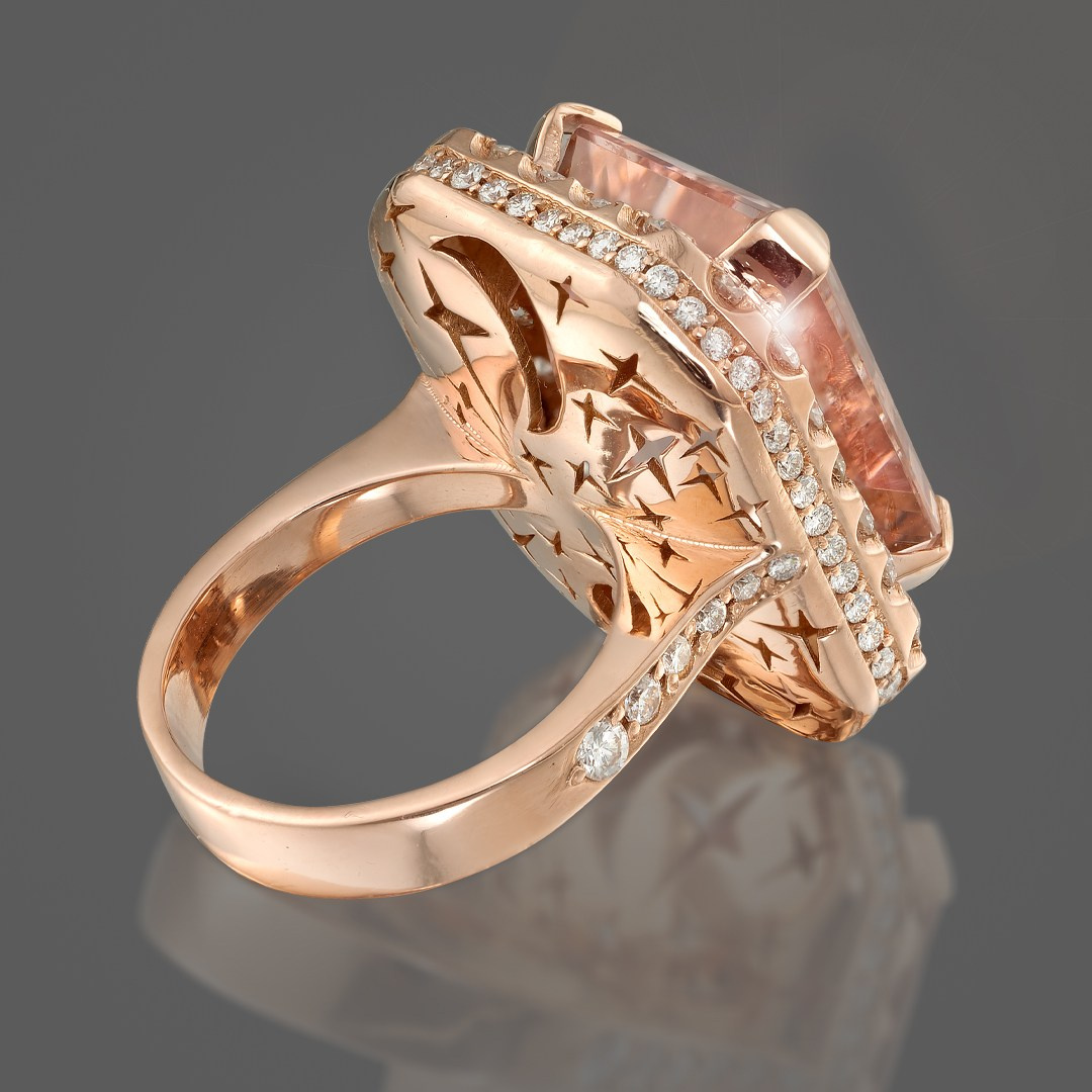 Zlatni prstena sa velikim centralnim kamenom na sivoj pozadini.