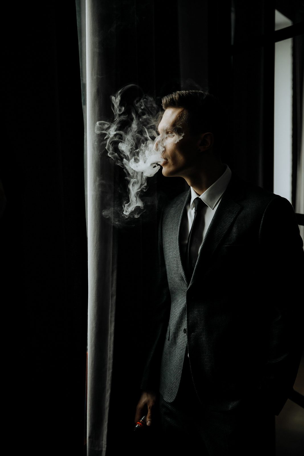 Groom’s morning smoke in light, by Tanya Bogdan, Bude editorial and reportage wedding photography.  