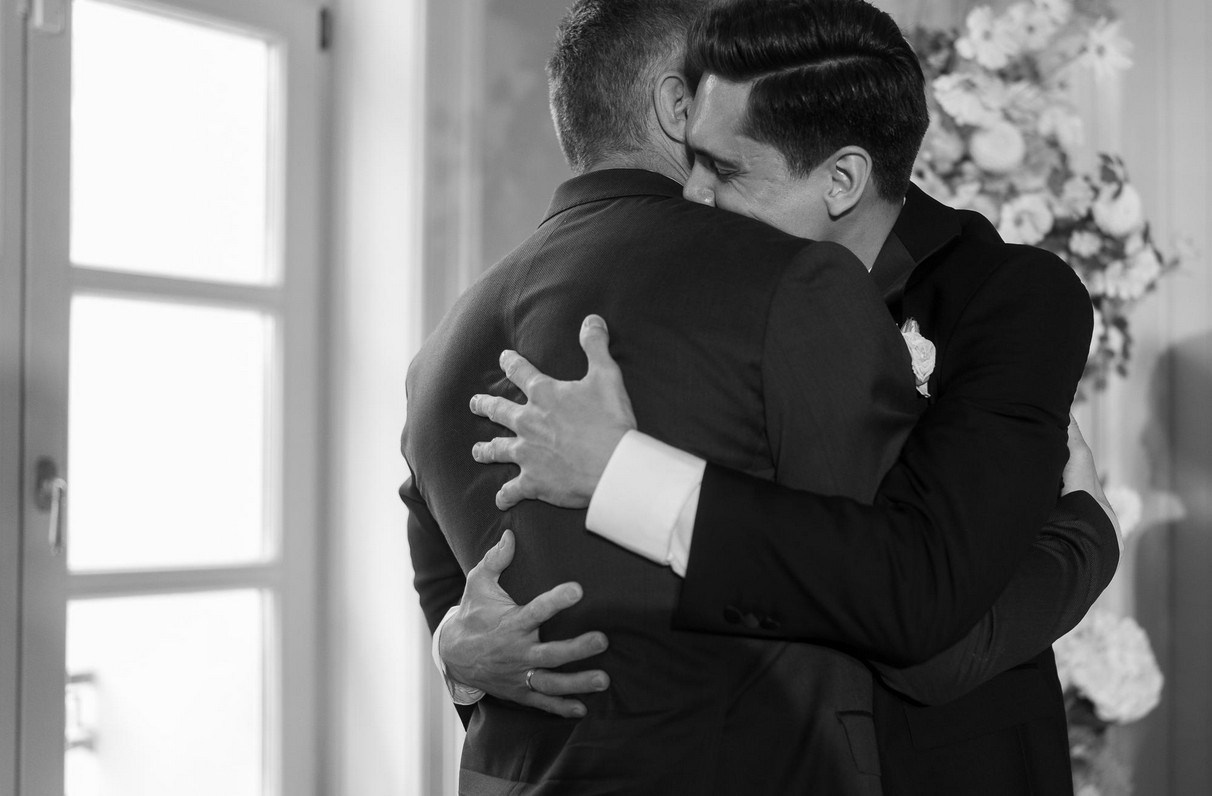 Father and groom sharing emotional hug