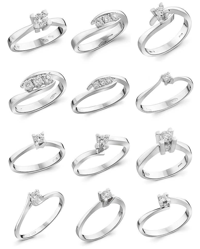 Puno zlatnog vereničkog prstenja na beloj pozadini.