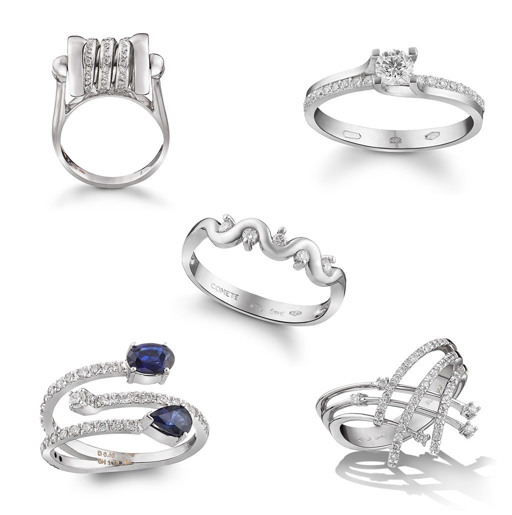 Pet zlatnih dijamantskih prstena na beloj pozadini.