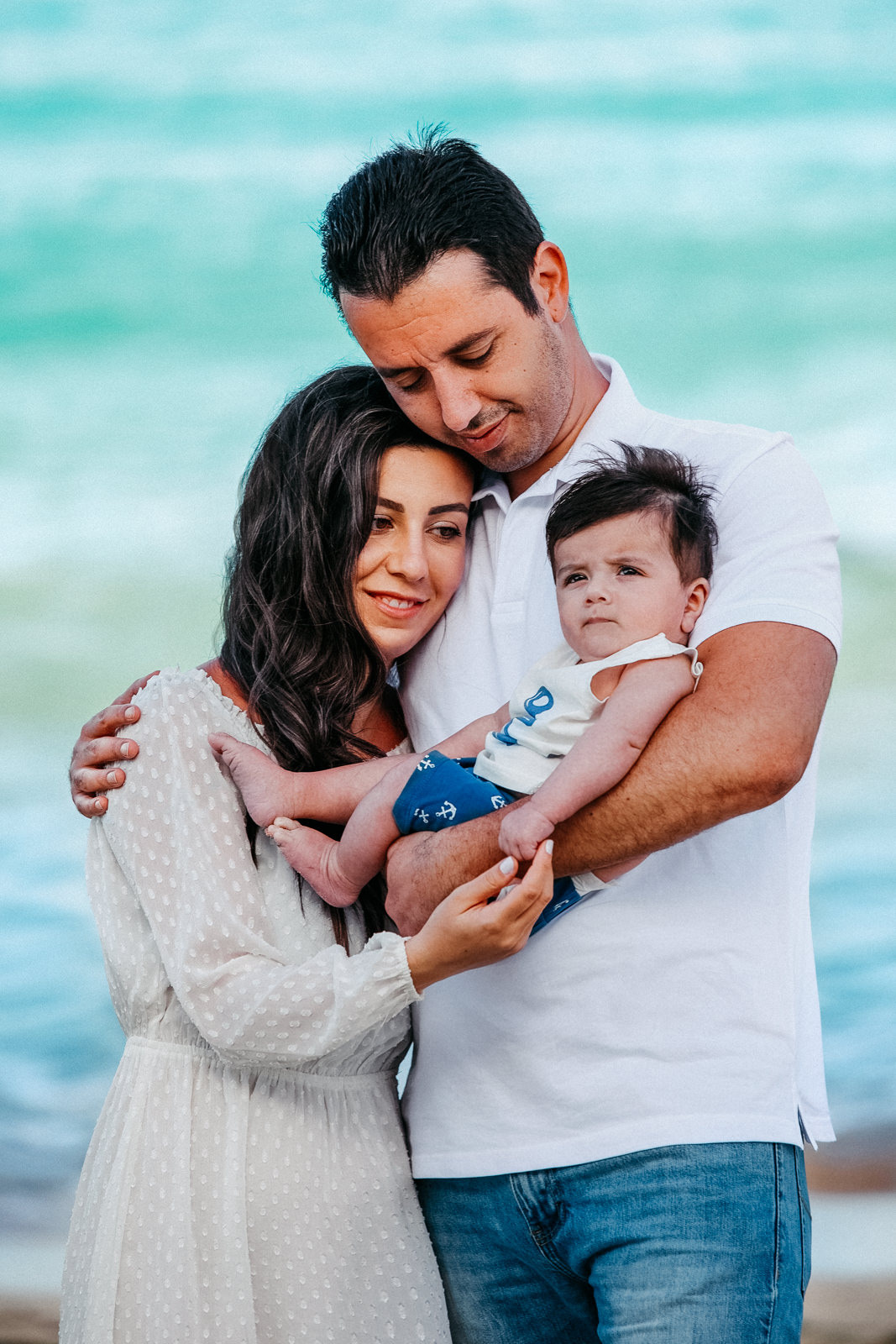 Un homme et une femme tenant un bébé sur la plage d'Amadores