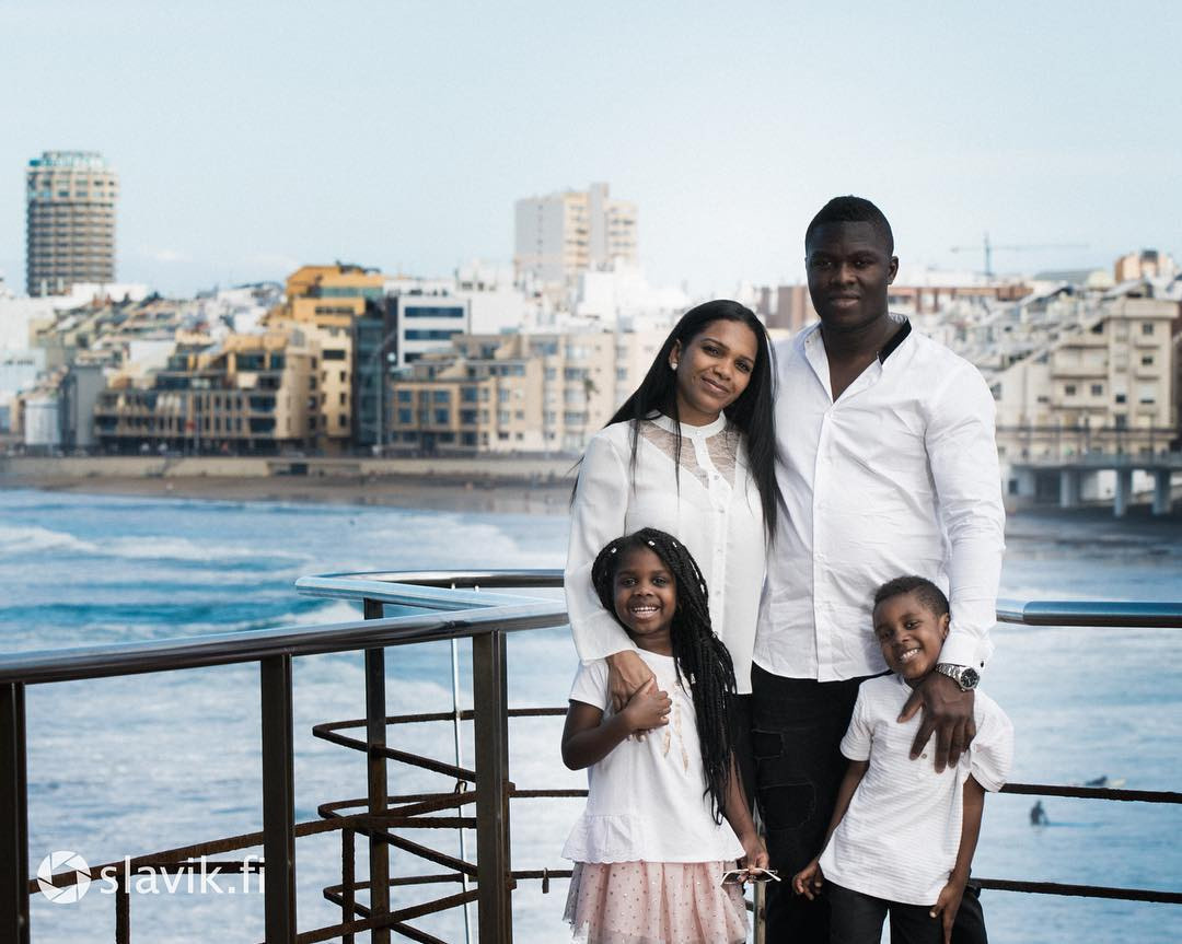 Une famille pose pour une photo sur un balcon surplombant l'océan à Las Palmas