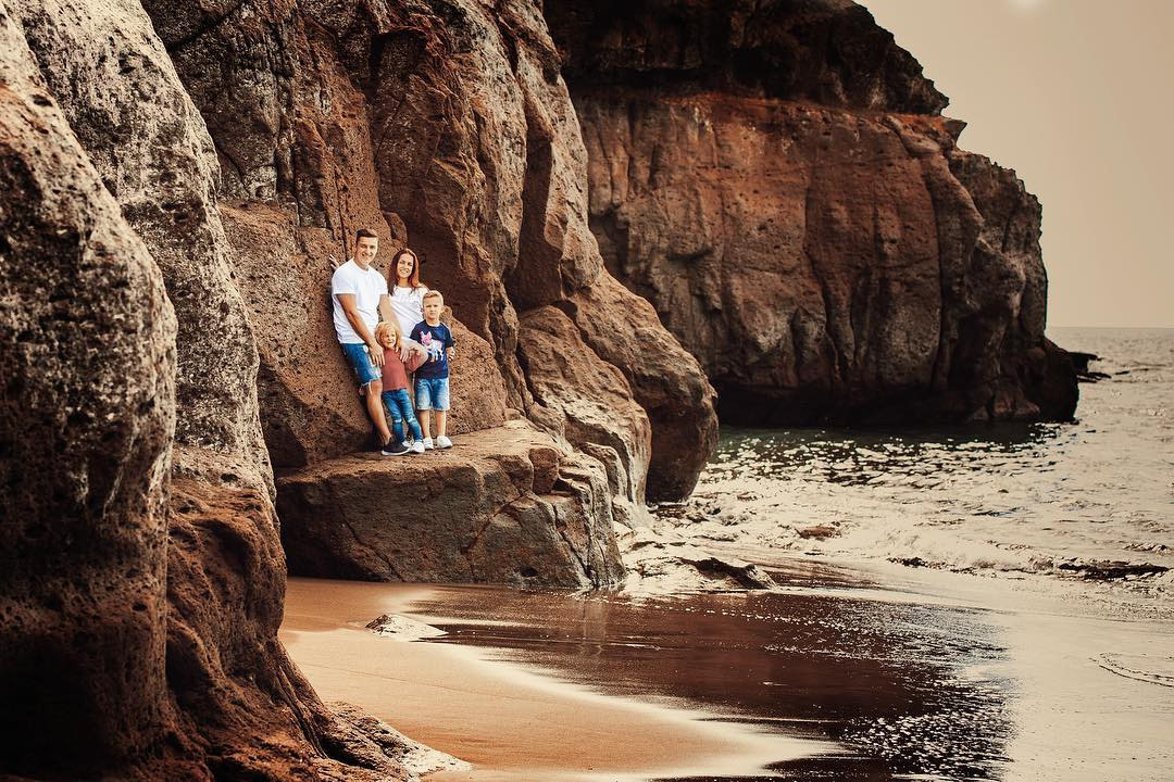 Un couple se tient sur une falaise près de l'océan Taurito