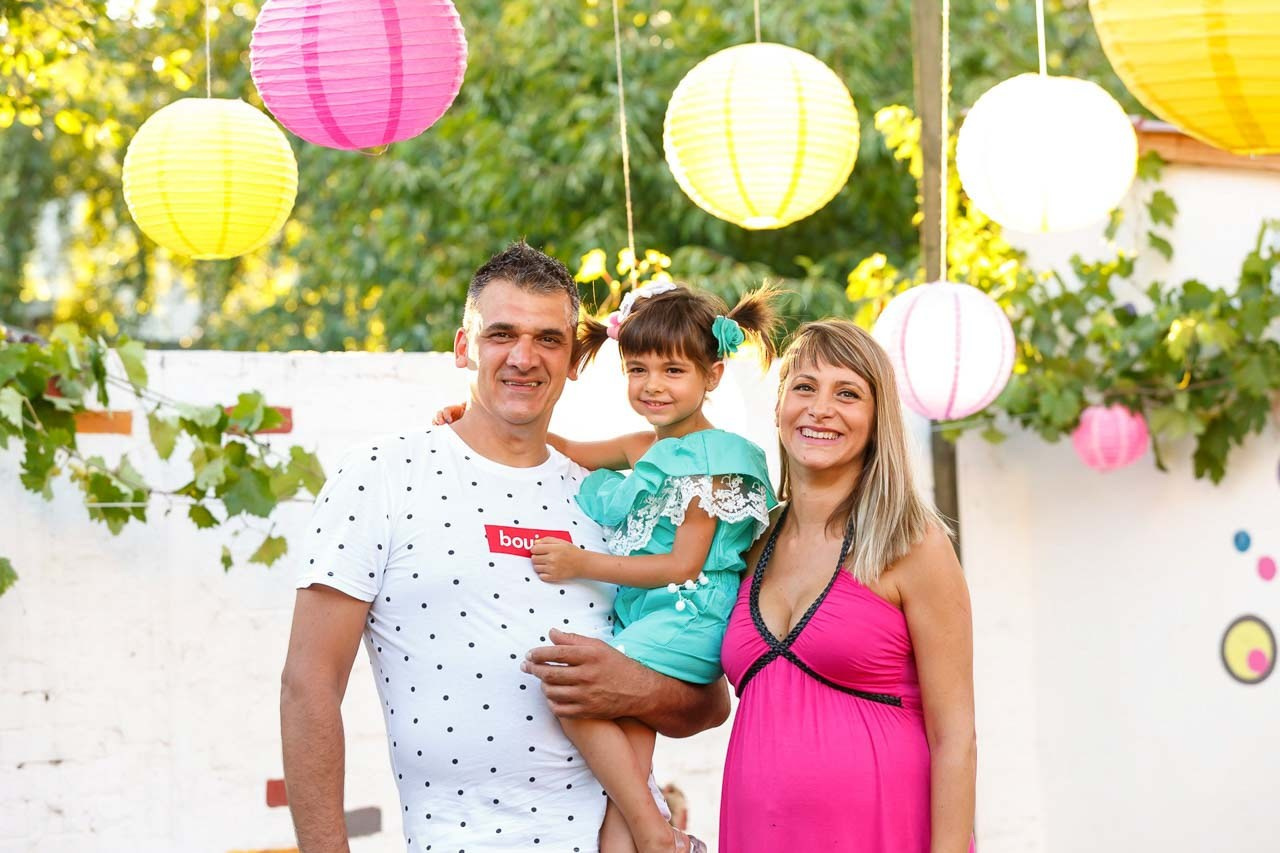 Ljubav i osmesi u prirodnom ambijentu za dečji rođendan. Porodična fotografija.