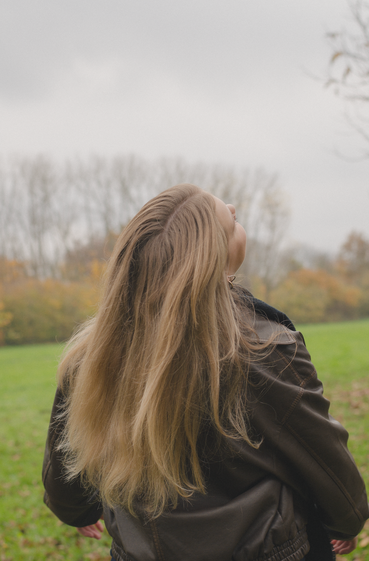 Porträt von hinten von einer jungen Frau mit Fokus auf ihre blonden Haare