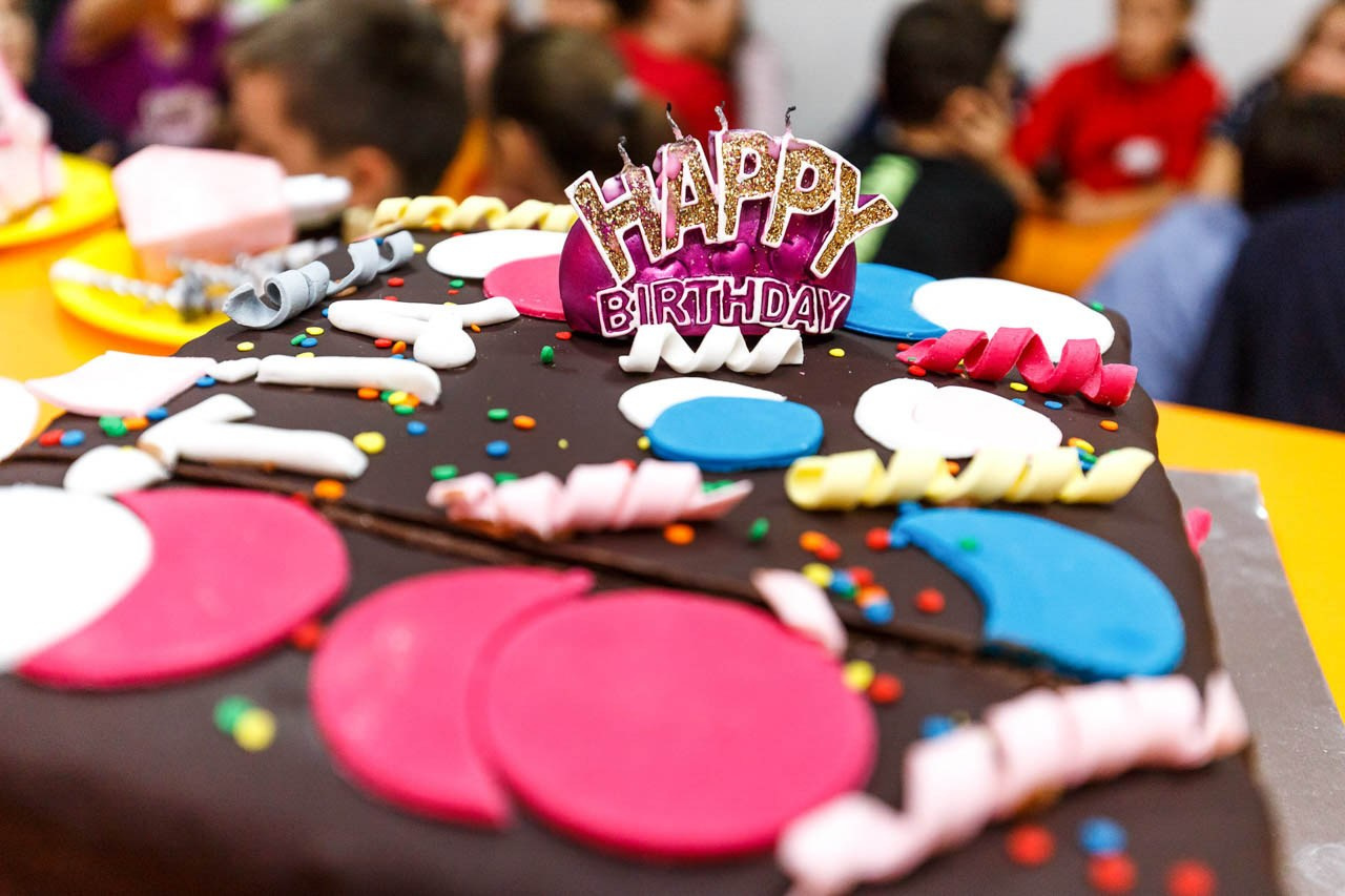 Kreativna torta sa detaljima u obliku oblaka i balona.