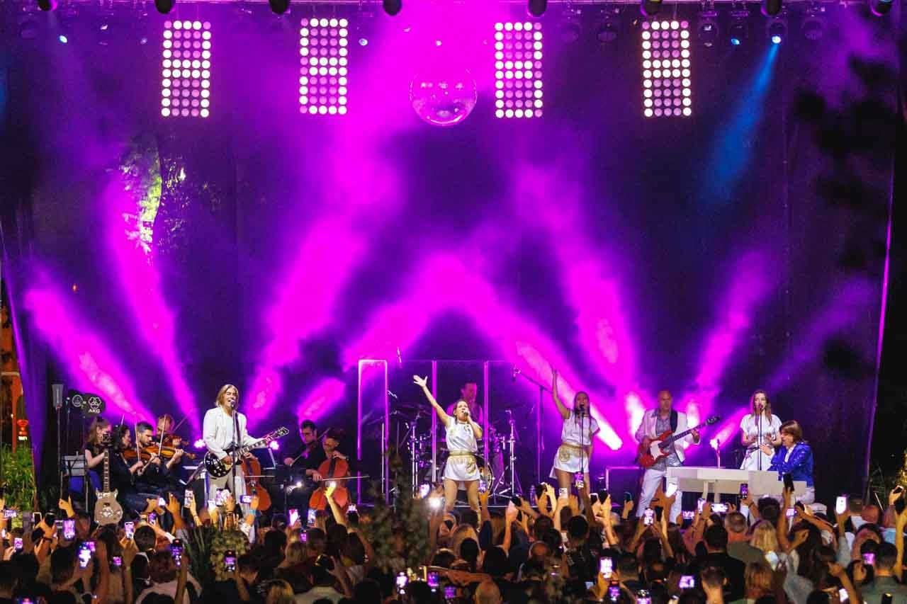 Dinamična izvedba na koncertu ABBA Ring Tribute benda uz vibrantne svetlosne boje i prepunom prostoru Botaničke bašte u Beogradu.