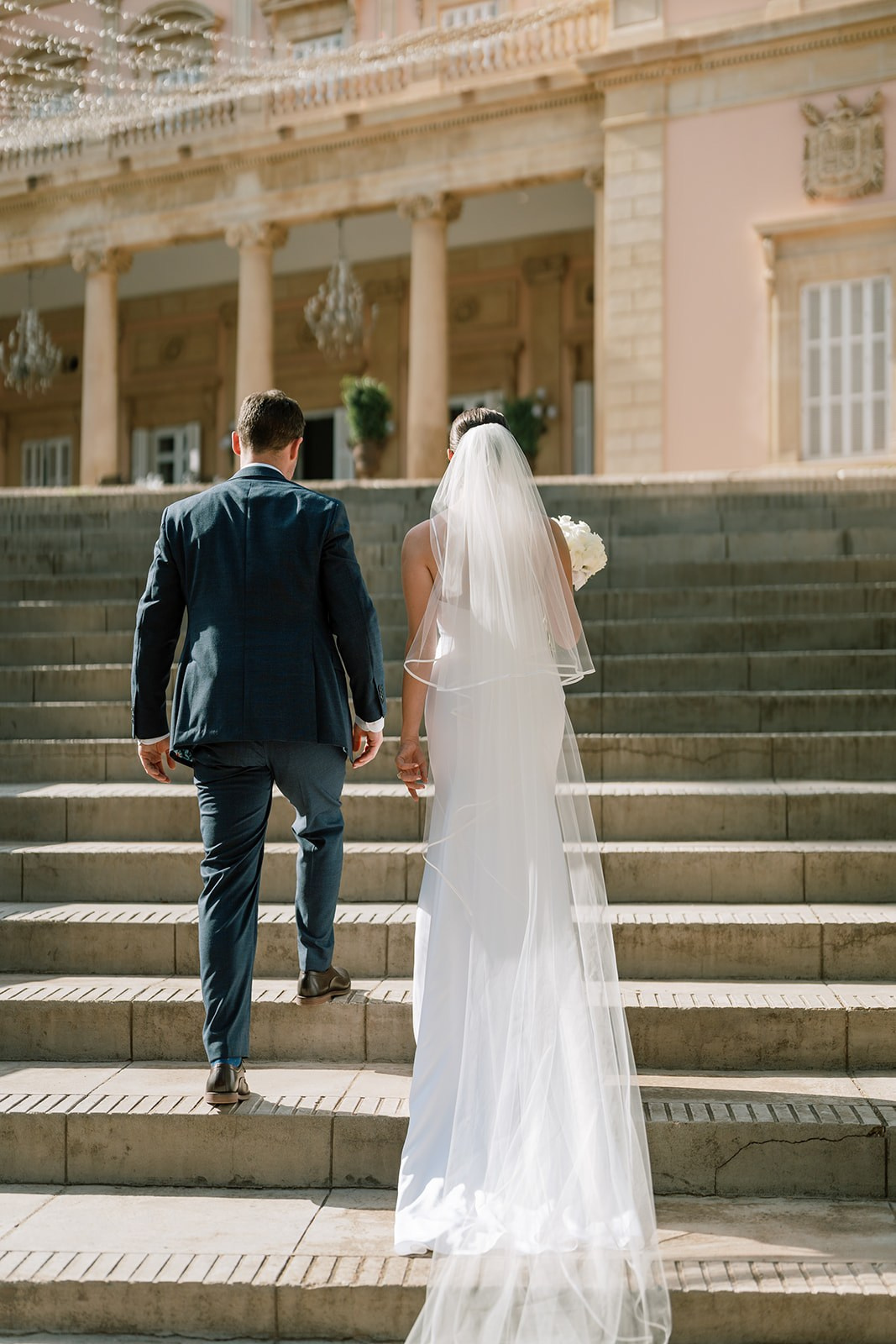 The groom and the bride are walking to the wedding venue