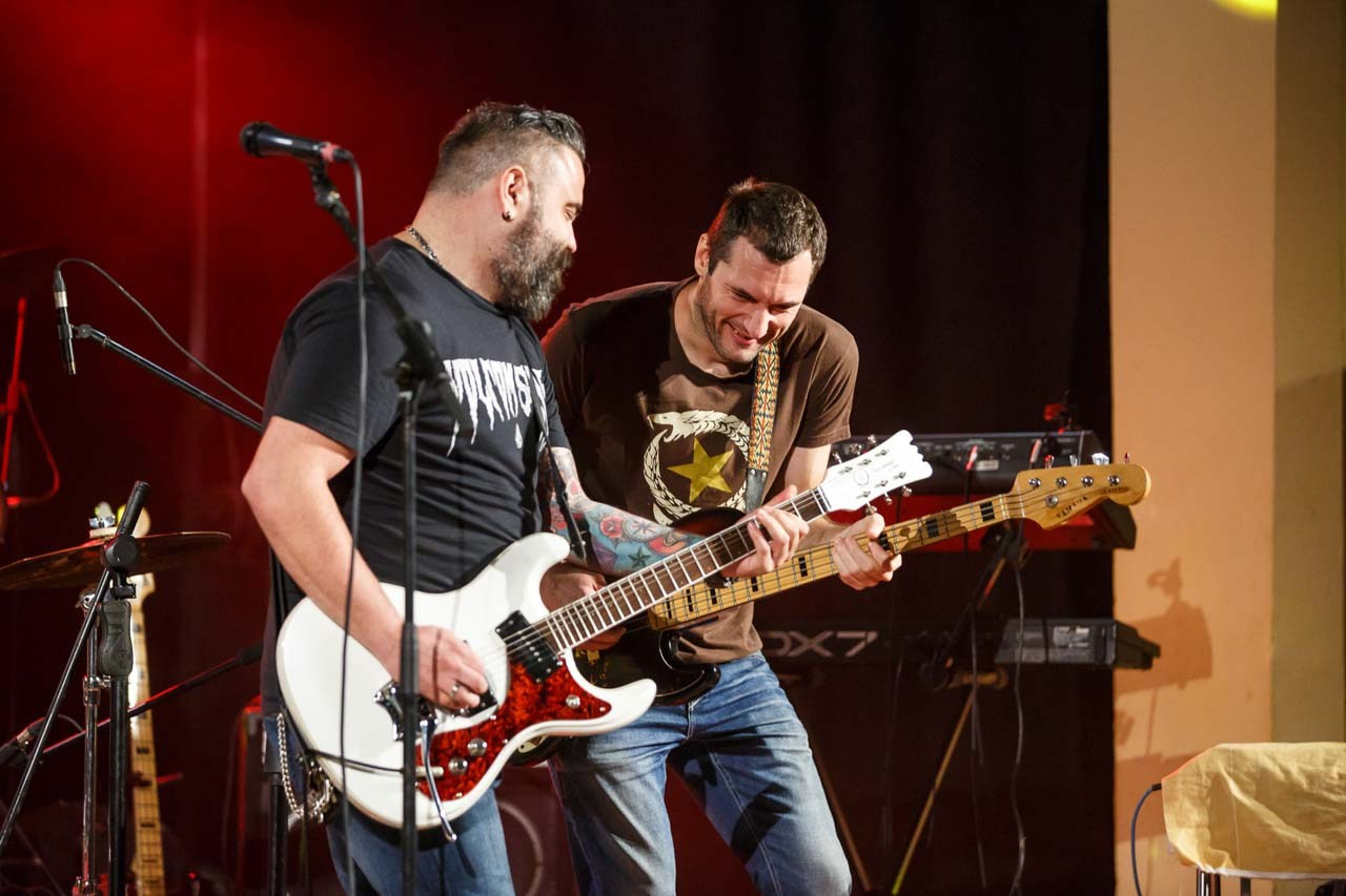 Kadar muzičara dok izvode energičnu pesmu sa električnim gitarama.