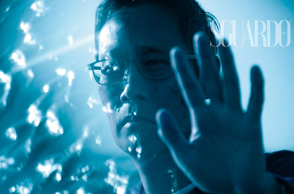 A man with a blue background with hand up, artistic photography by Irina Zoteeva. Lifestyle photography Solihull and Birmingham. Artistic photographer Solihull and Birmingham.