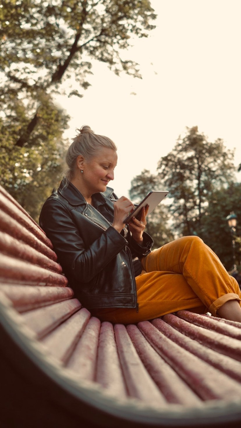 Ragazza seduta su una panchina, che disegna.