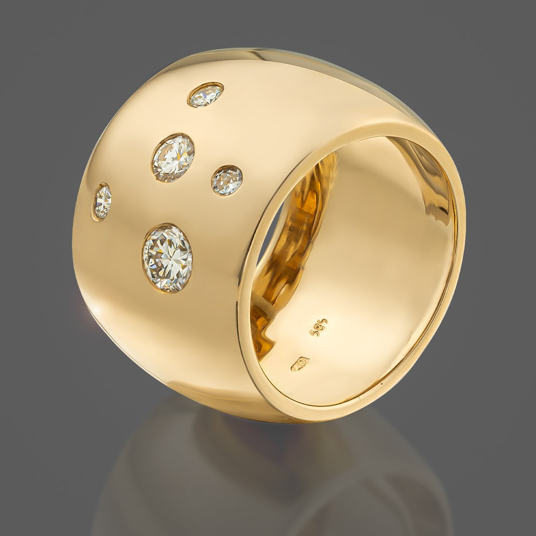 Zlatna široka zlatna burma na sivoj pozadini.