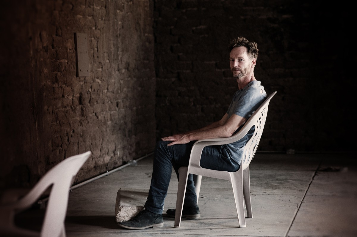Art the curator  Theo Tegelaers on the chair in the cave.