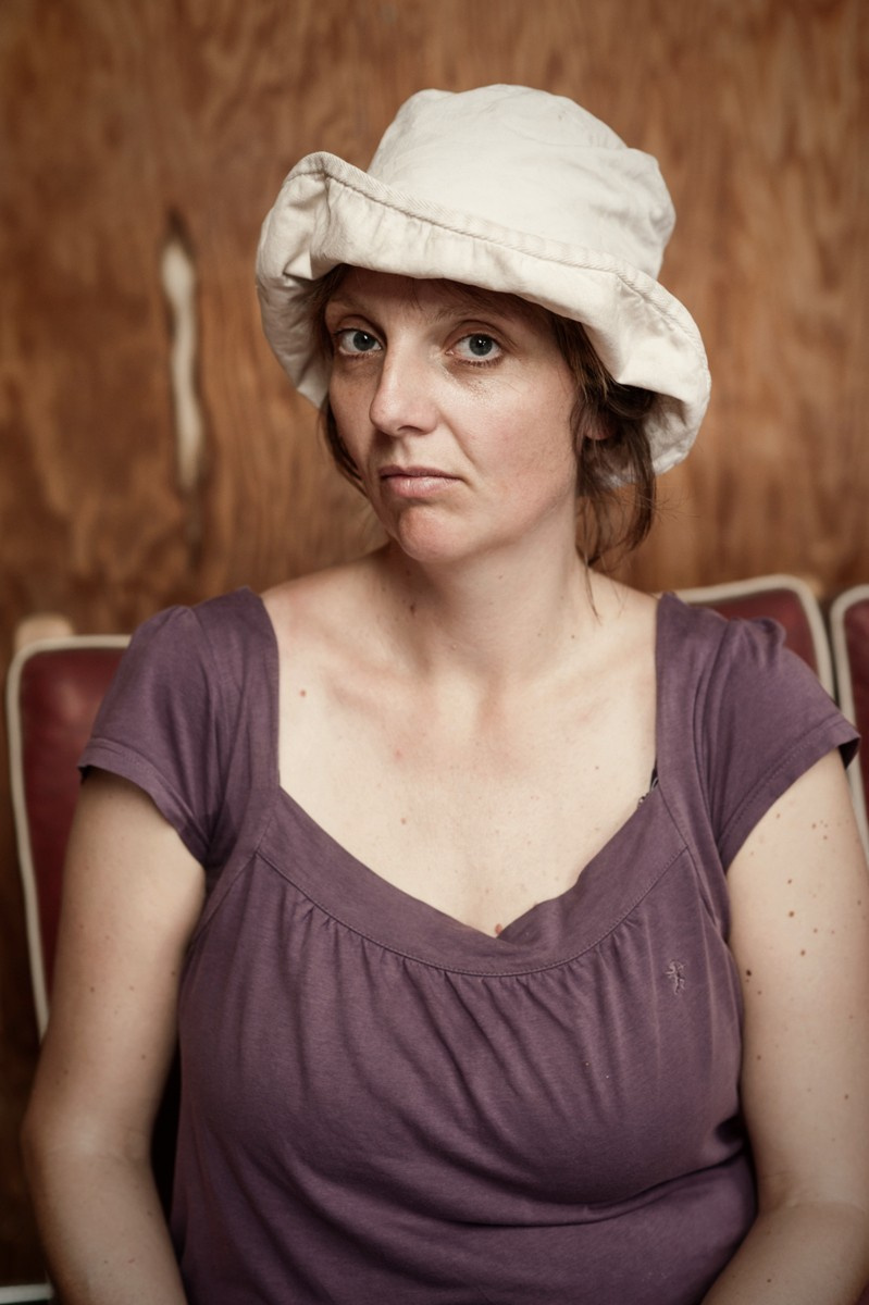 A portrait of a young woman in a small white hat.