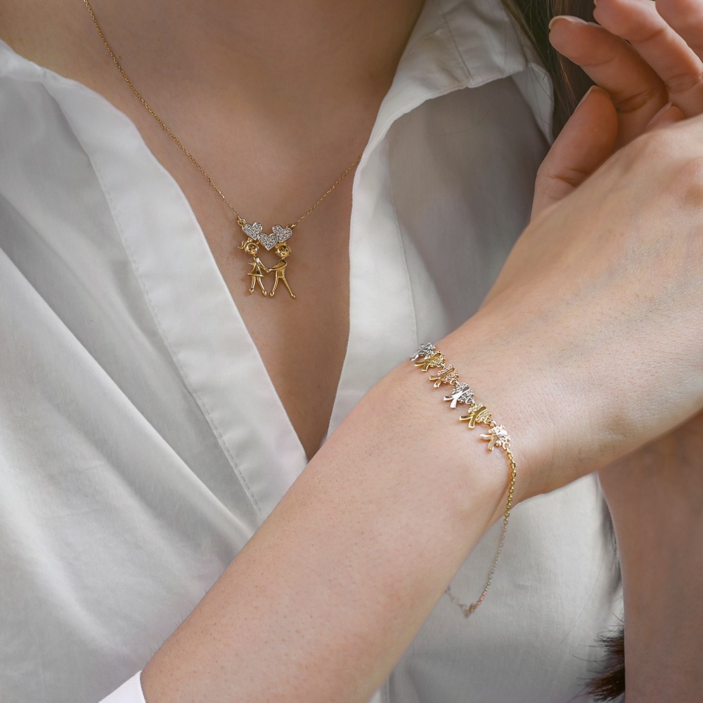 Zlatna narukvica i ogrlica na devojci u beloj košulji.